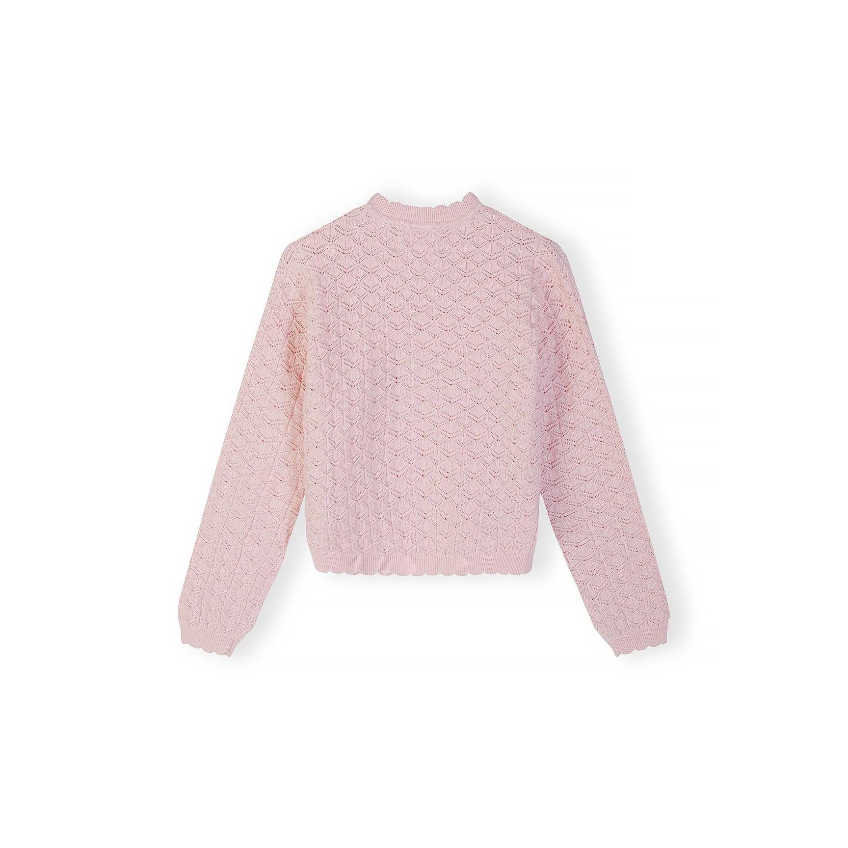 Pink jumper laid flat showing wave hem detail and pointelle knit pattern against white background
