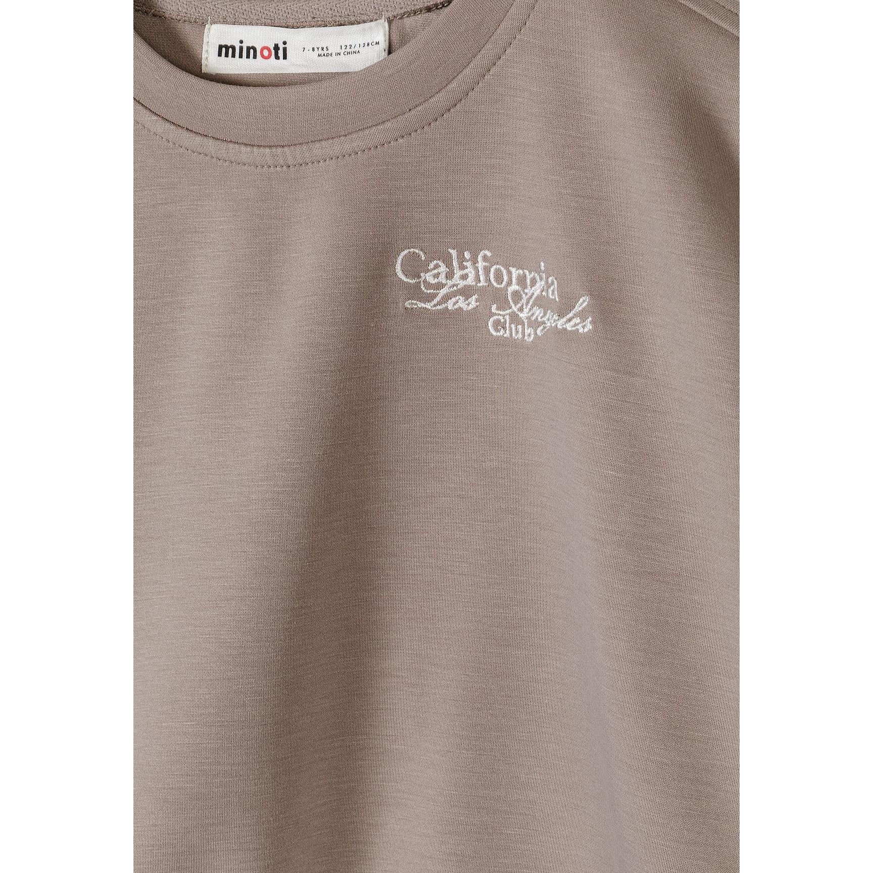 Close-up detail of Minoti label and California Los Angeles Club embroidery on brown sweatshirt fabric