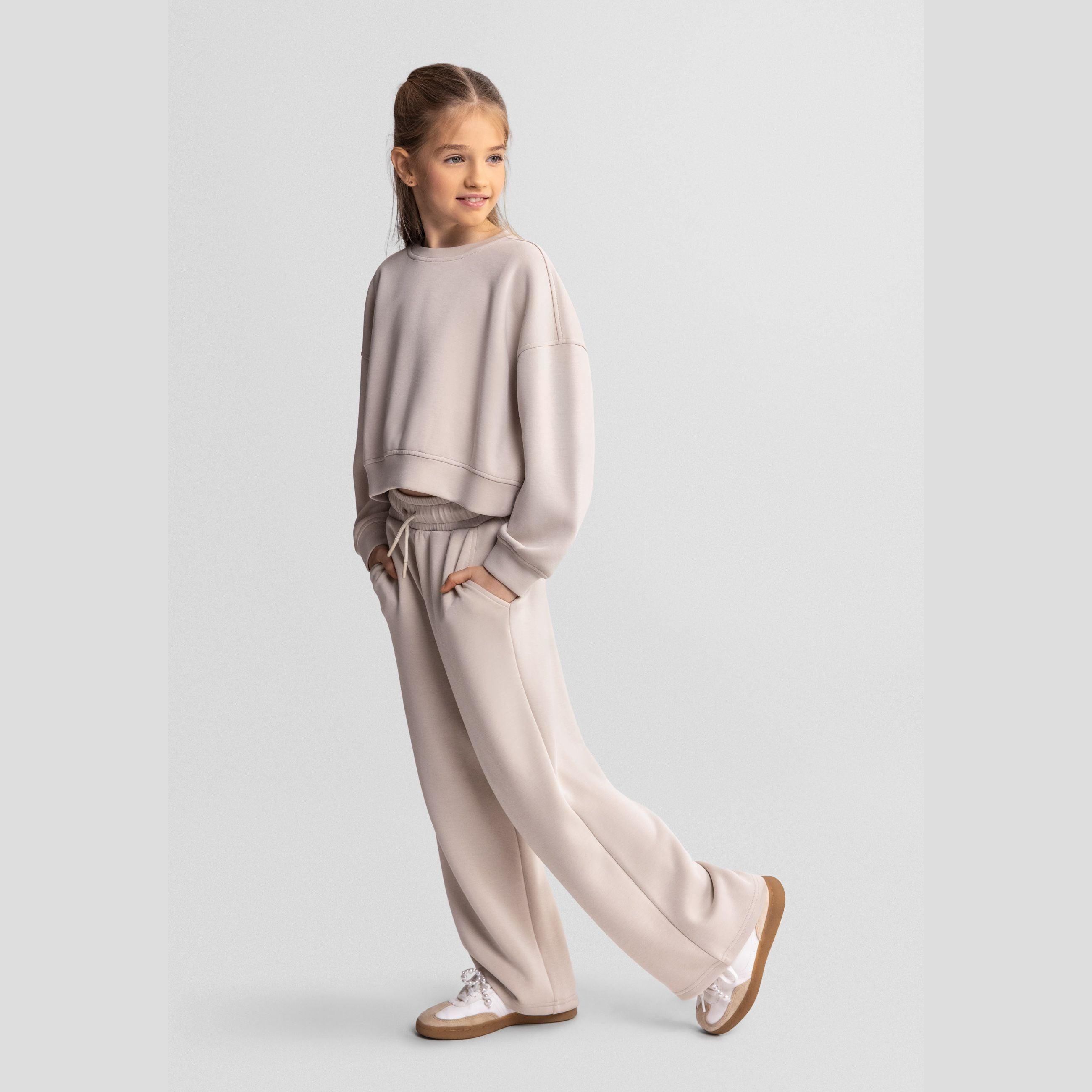 Close-up detail of beige joggers waistband showing Minoti label and adjustable drawstring ties with elastic waist