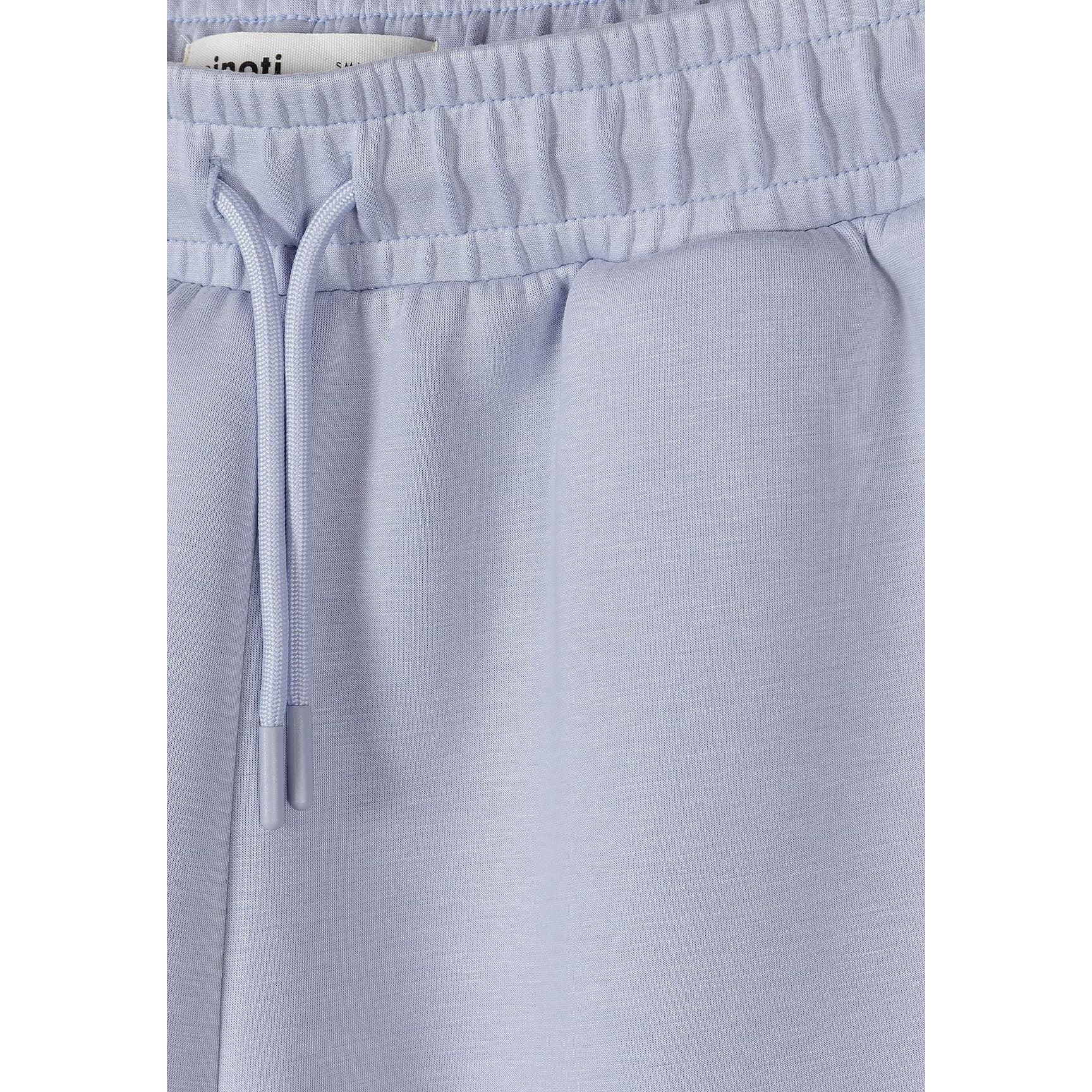 Detail view of shorts waistband showing Minoti label, elastic band and drawstring ties