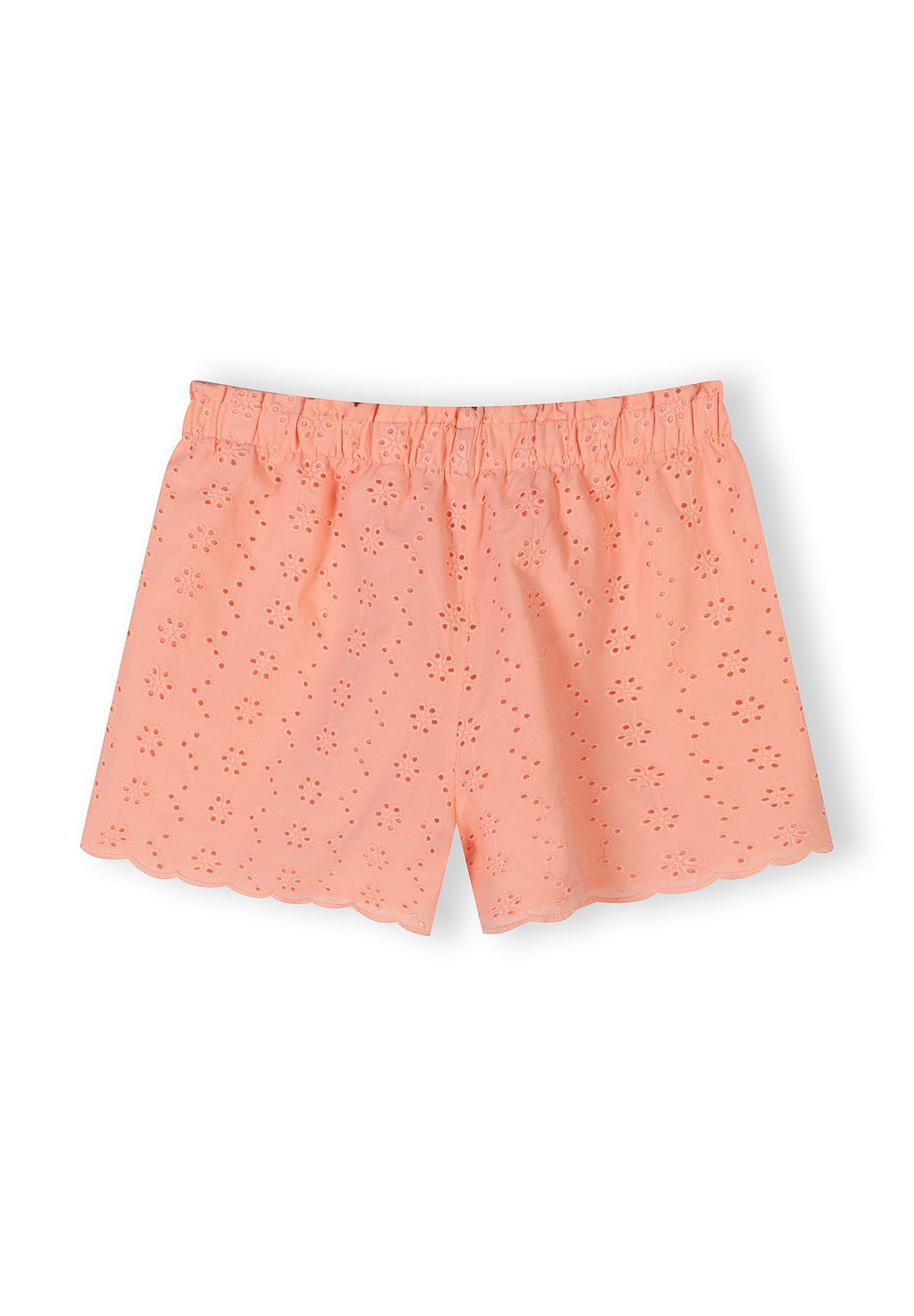 Close-up detail of apricot cotton fabric showing delicate broderie anglaise eyelet embroidery pattern with floral motifs and elasticated waistband