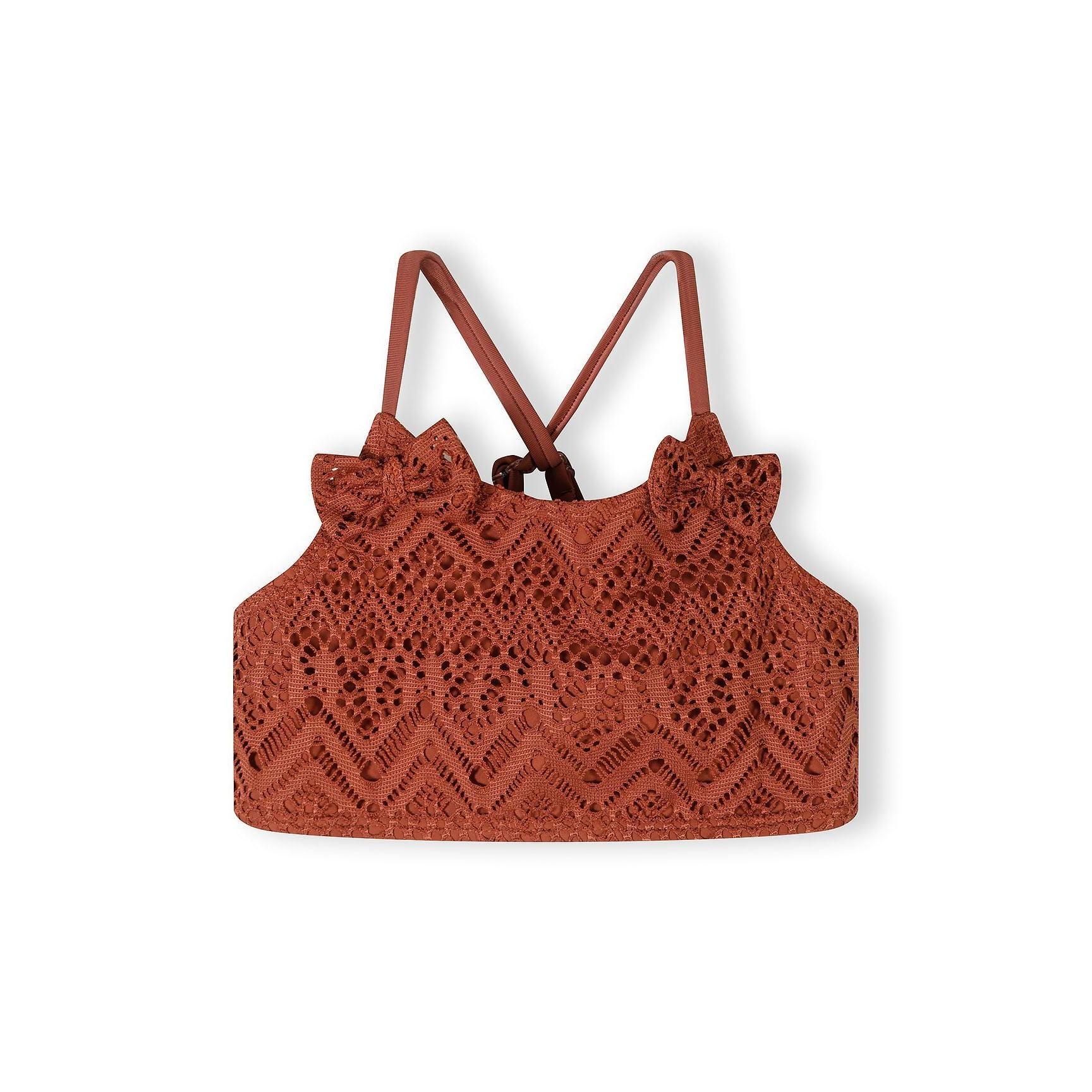 Close-up detail of copper crochet bikini showing intricate diamond and geometric lace pattern with gold charm detail on adjustable strap