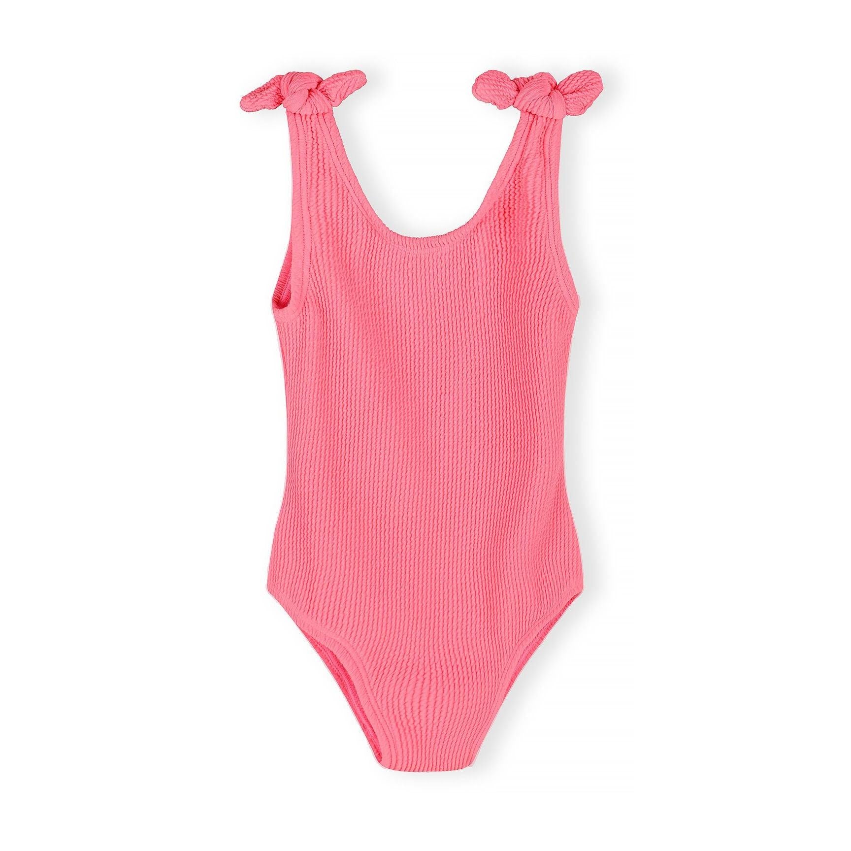 Close-up detail of coral pink ribbed swimsuit fabric showing textured surface and tie shoulder strap against white background