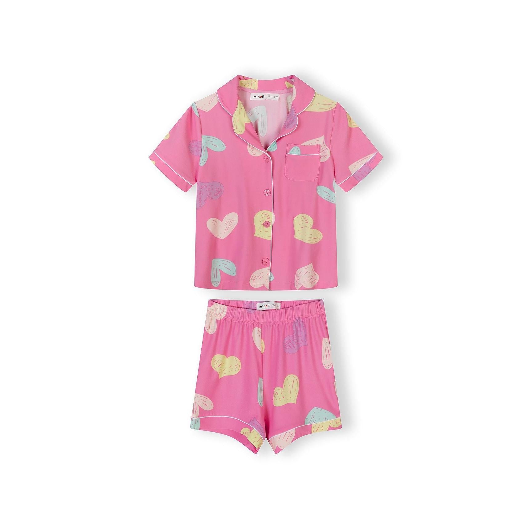 Close-up detail of pink pajama top with colorful heart pattern and white piping trim around collar and pocket