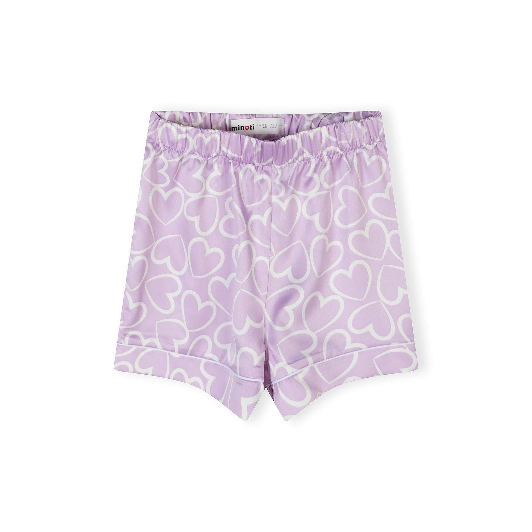 Close-up view of lilac satin pyjama shorts with white heart print pattern and Minoti label visible at waistband