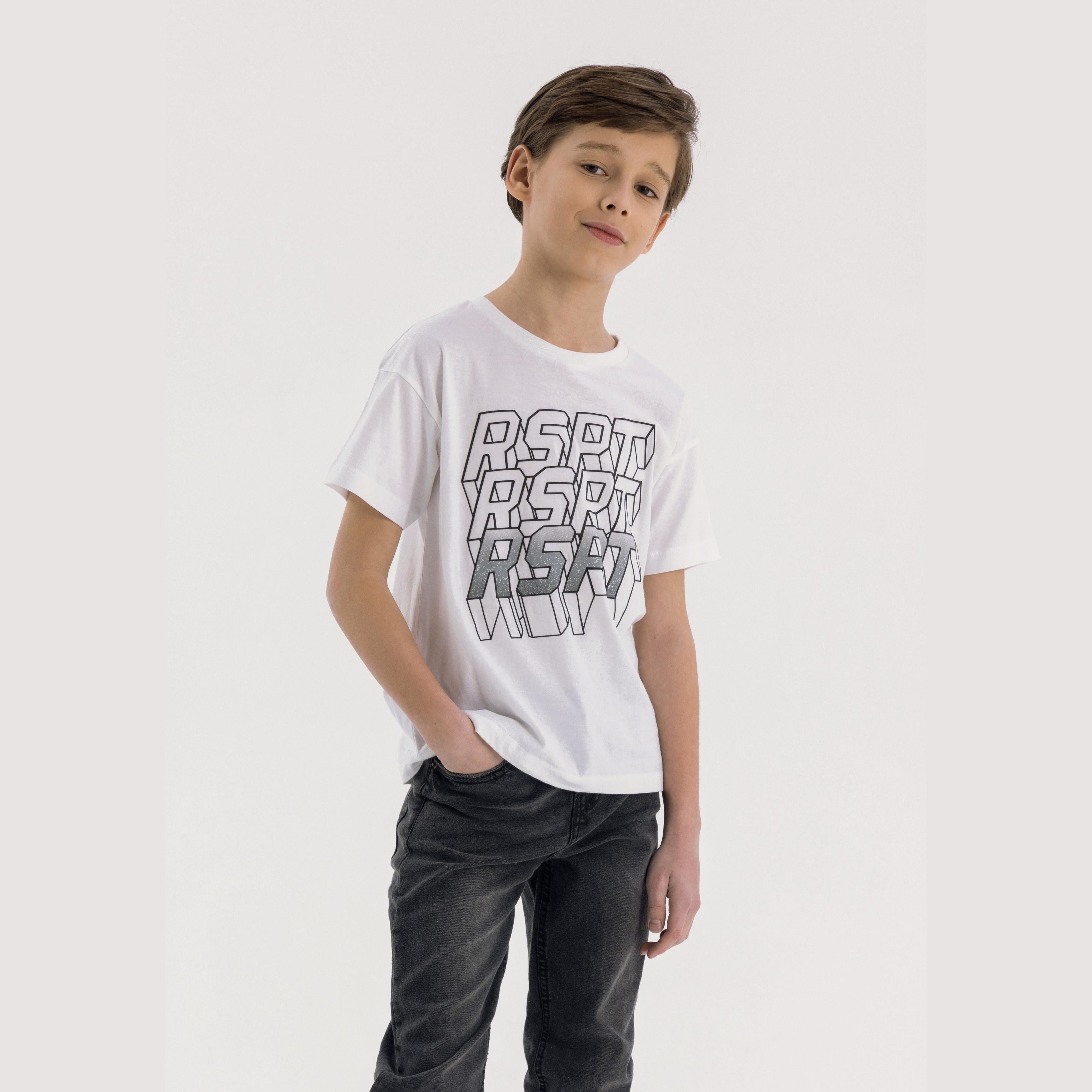 Young boy wearing white crew neck t-shirt with black RSRP graphic print and dark jeans, standing against light grey background