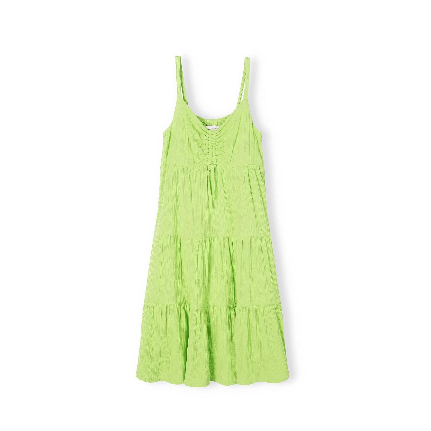 Bright green tiered strappy dress laid flat showing three-tier skirt design and adjustable shoulder straps on white background