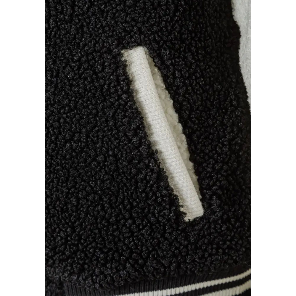 Close-up detail of black borg teddy fleece texture showing soft pile fabric surface