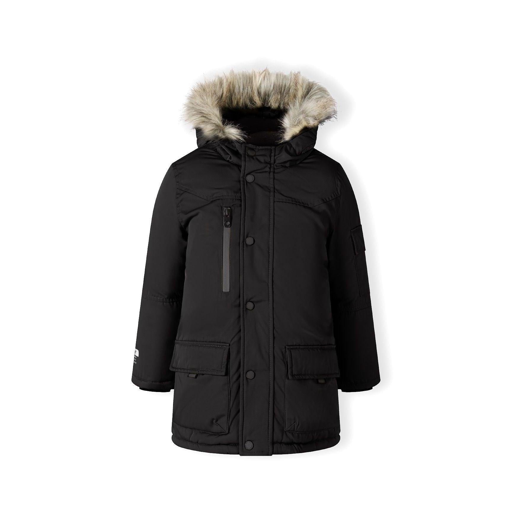 Same young boy in black long parka with faux fur hood, slightly different angle showing full silhouette