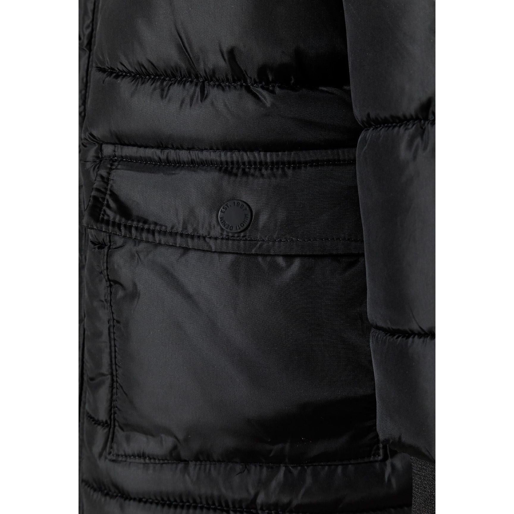 Close-up detail of faux fur hood trim and black fabric showing quilted pattern and zipper details
