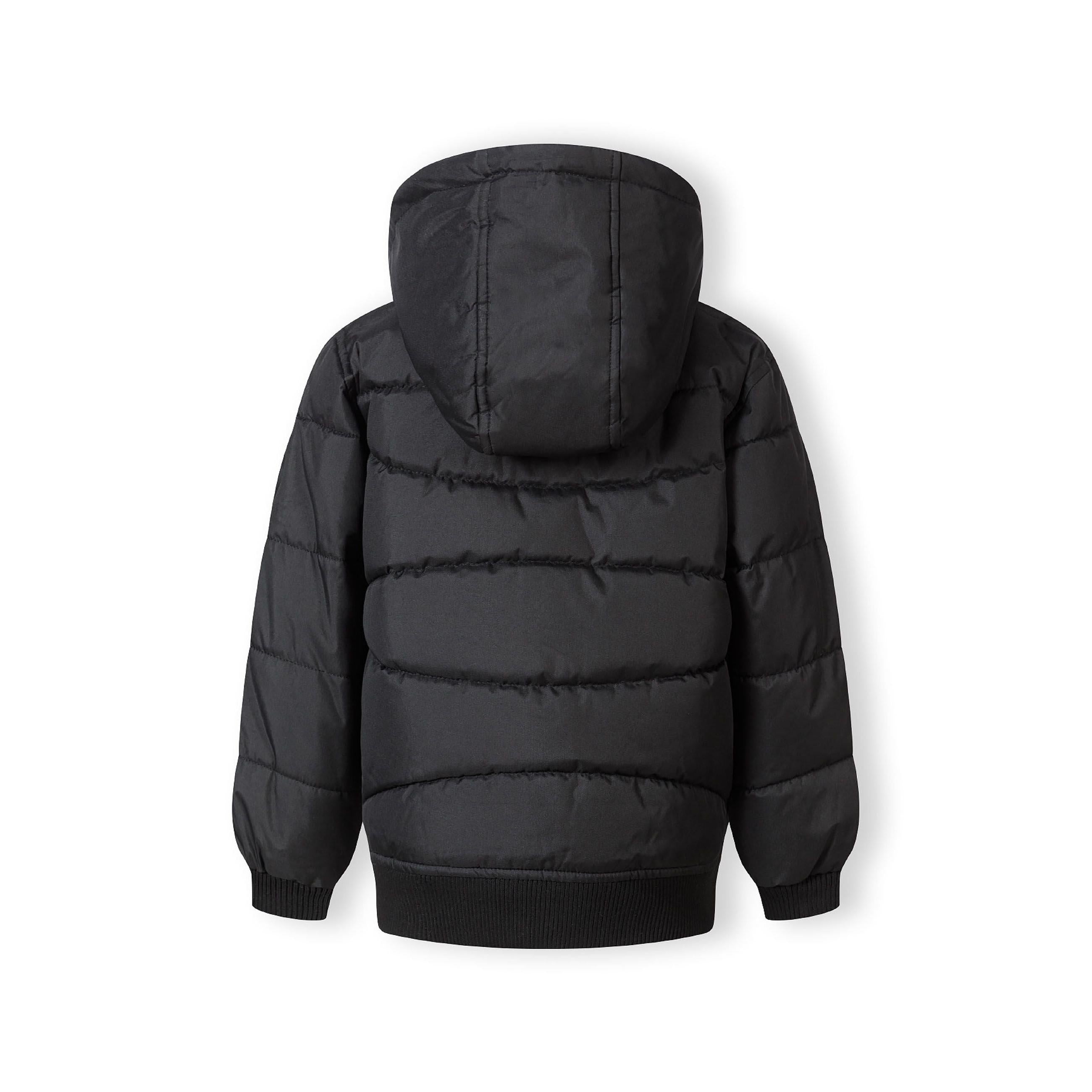 Close-up detail of black circular Minoti logo patch on the sleeve of the padded jacket showing MT 97 branding