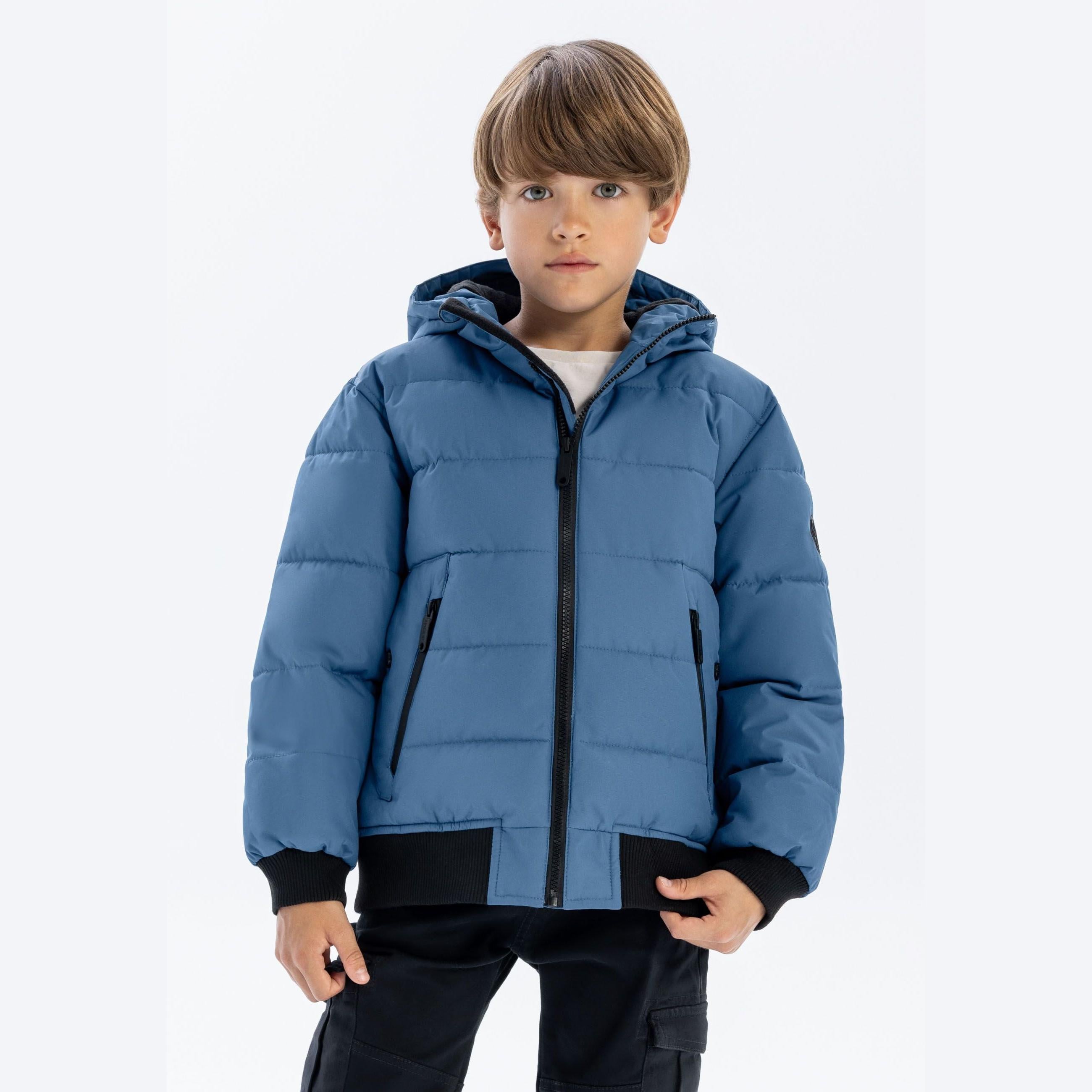 Same young boy in blue padded jacket, front view showing hood and zip closure detail