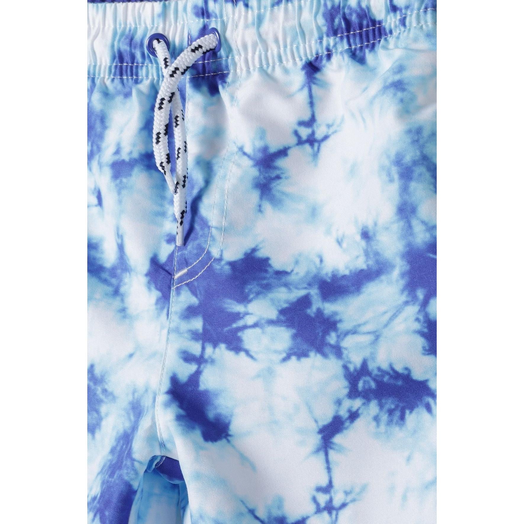 Close-up detail of elasticated waistband with white drawstring ties against blue tie-dye fabric pattern