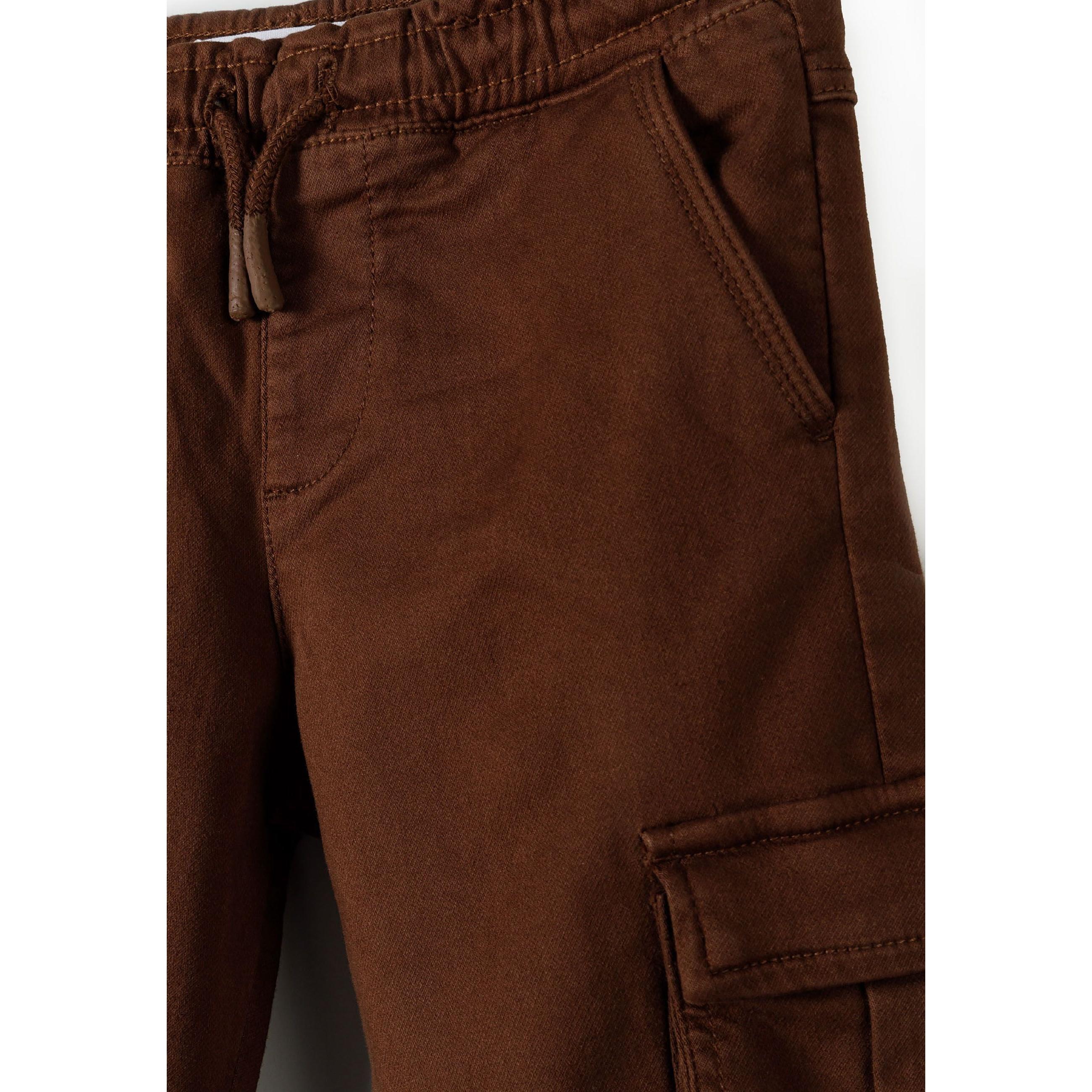 Close-up detail of brown cargo trousers showing side cargo pocket, fabric texture and construction quality