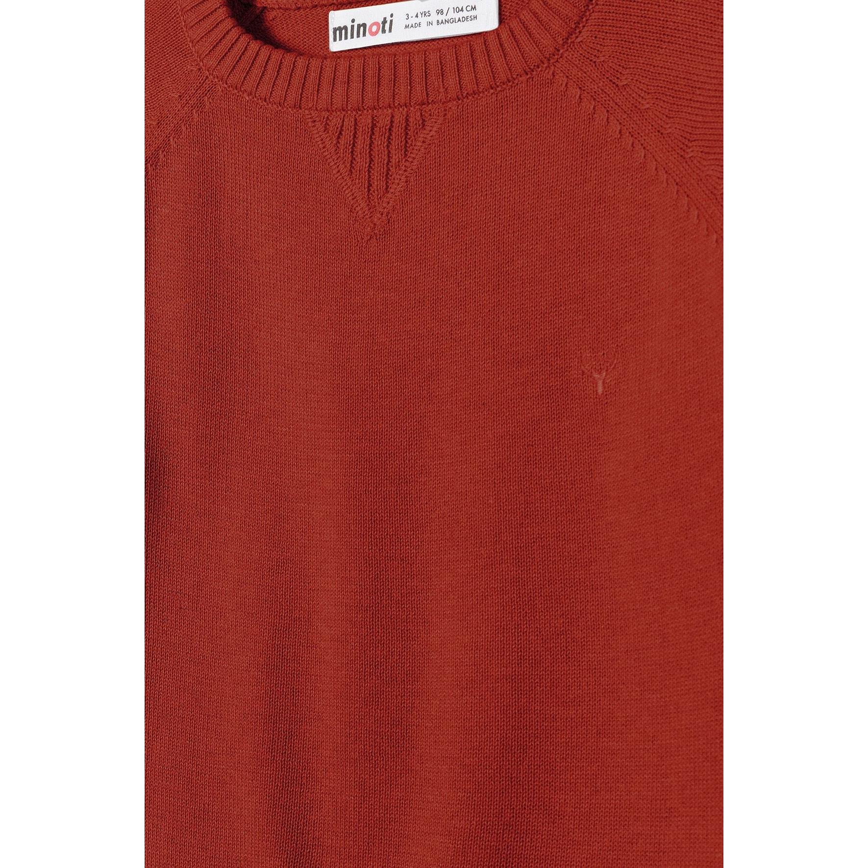 Close-up detail of red knitted jumper showing crew neck with V-insert and Minoti brand label