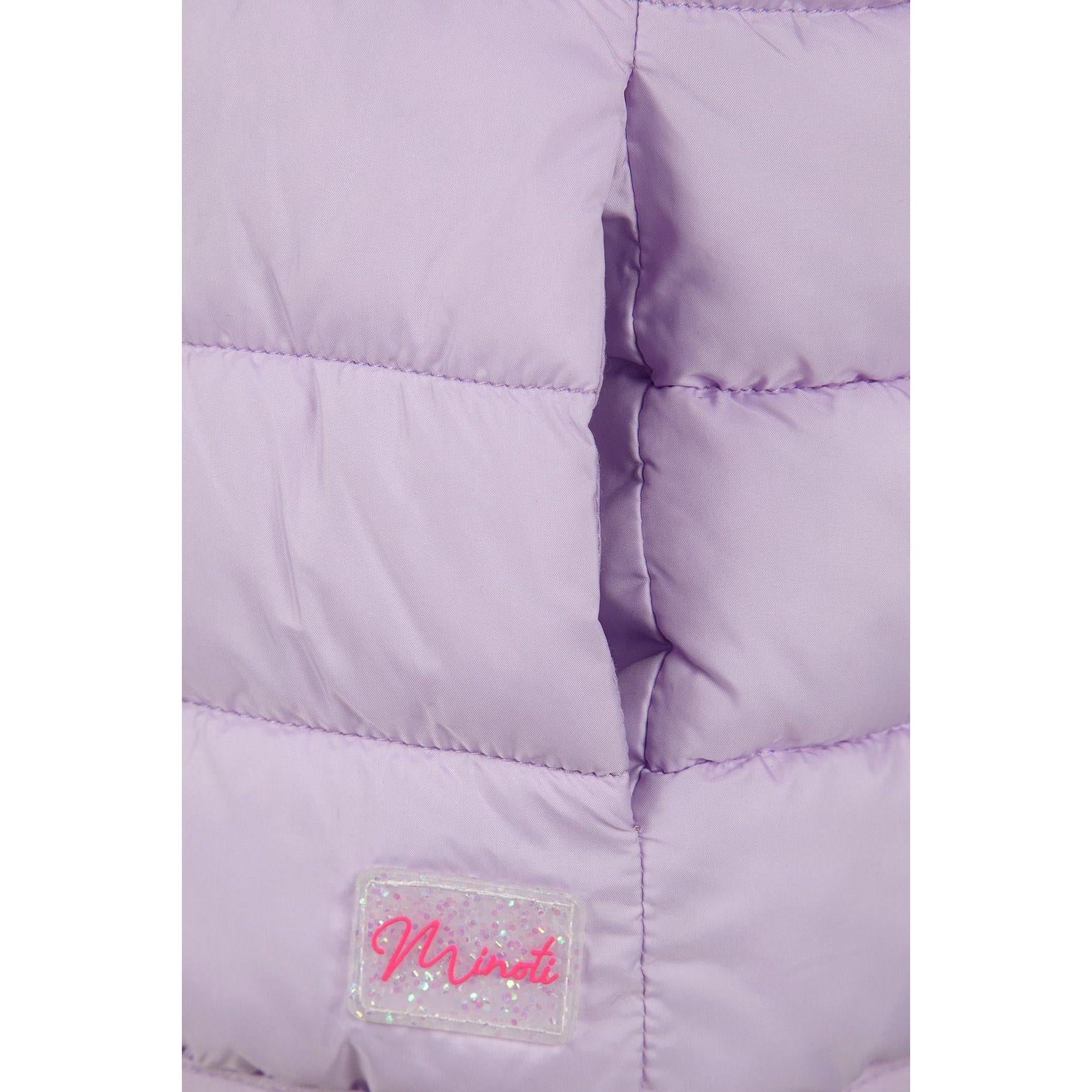 Close-up detail of lilac quilted fabric texture showing stitching pattern and Minoti brand label with glitter finish