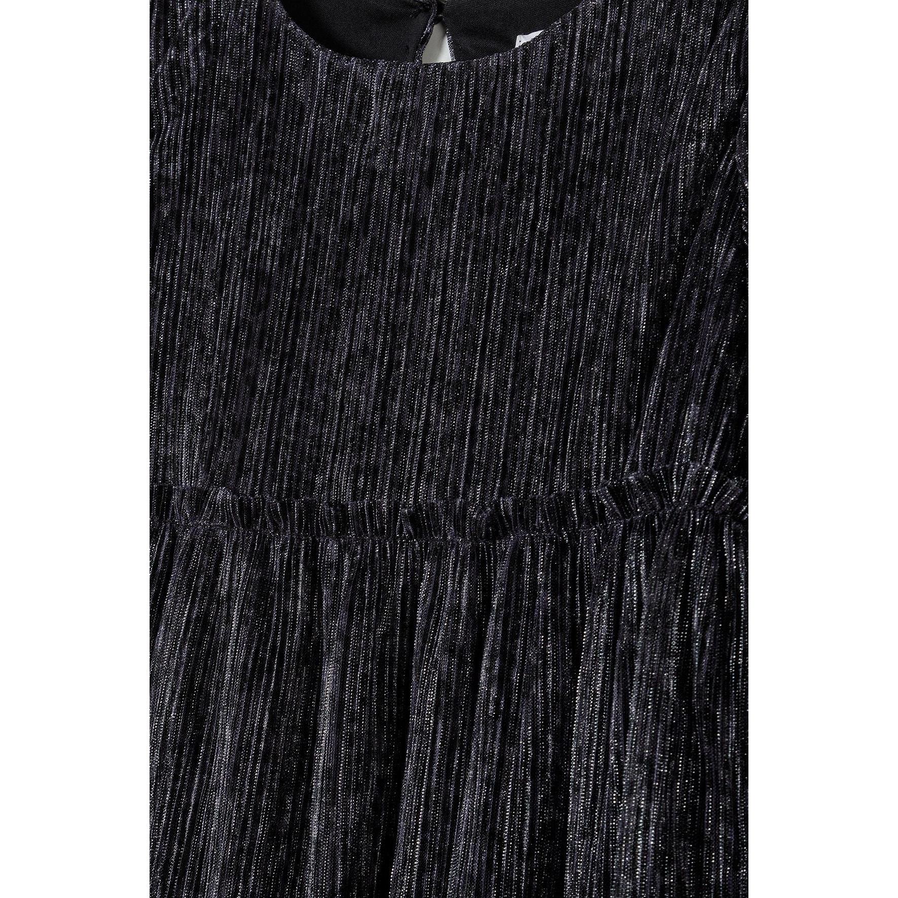 Close-up detail of black sparkle fabric texture showing shimmer effect and gathered waistline of party dress