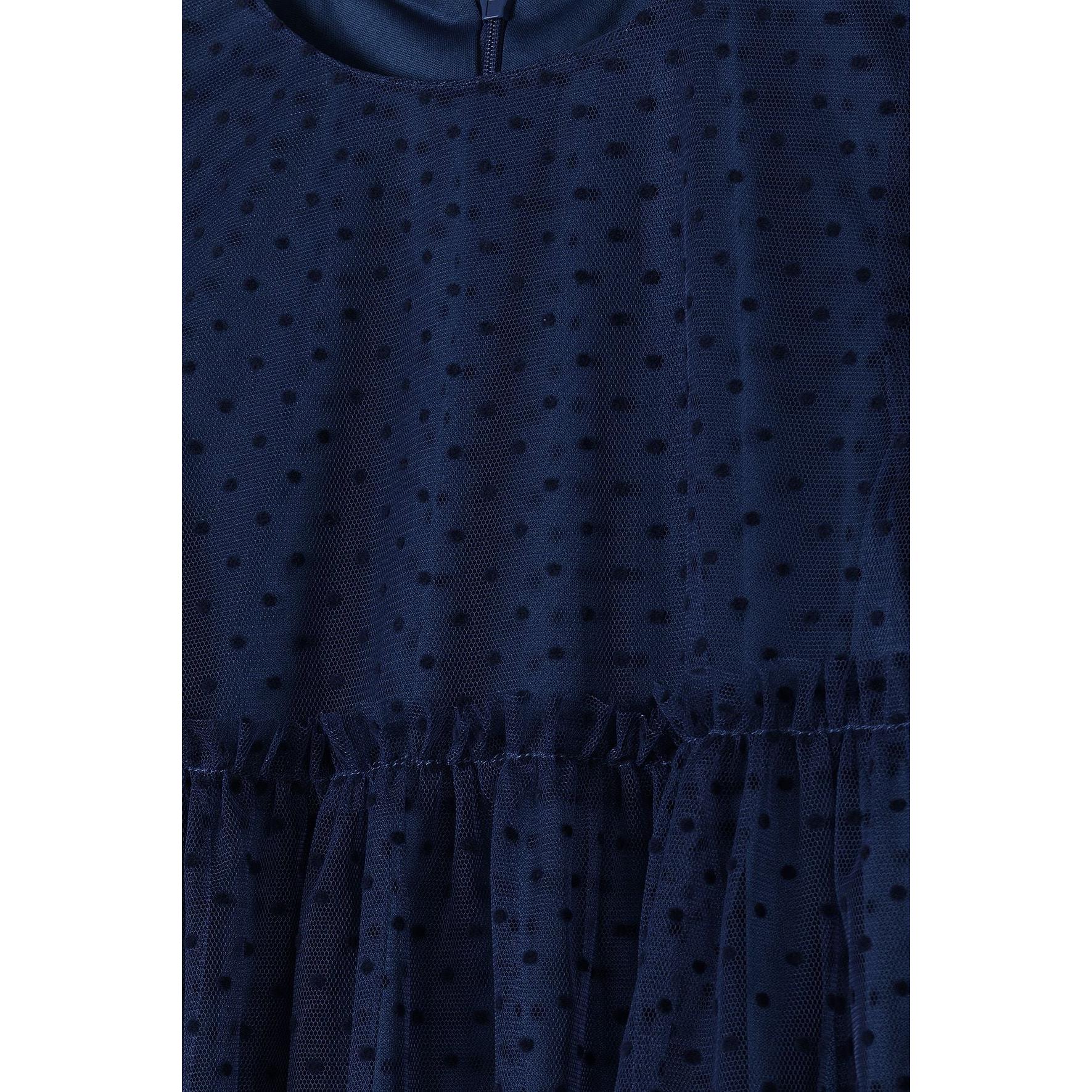 Close-up detail shot of navy flock print pattern on net fabric showing dotted texture and gathered waistline construction of the party dress