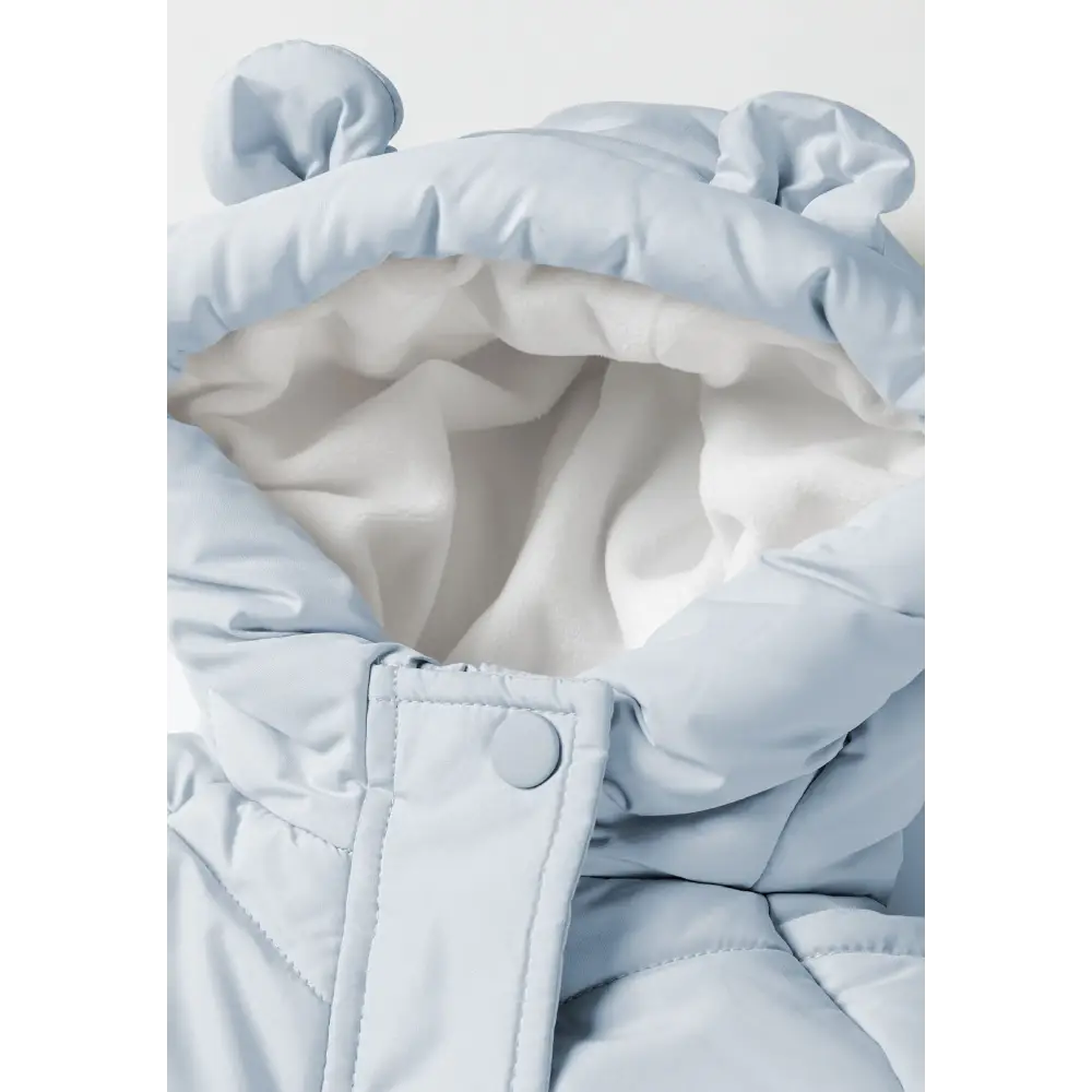 Detail view of light blue snowsuit foot section with elasticated ankle cuff and gathered fabric construction on white background