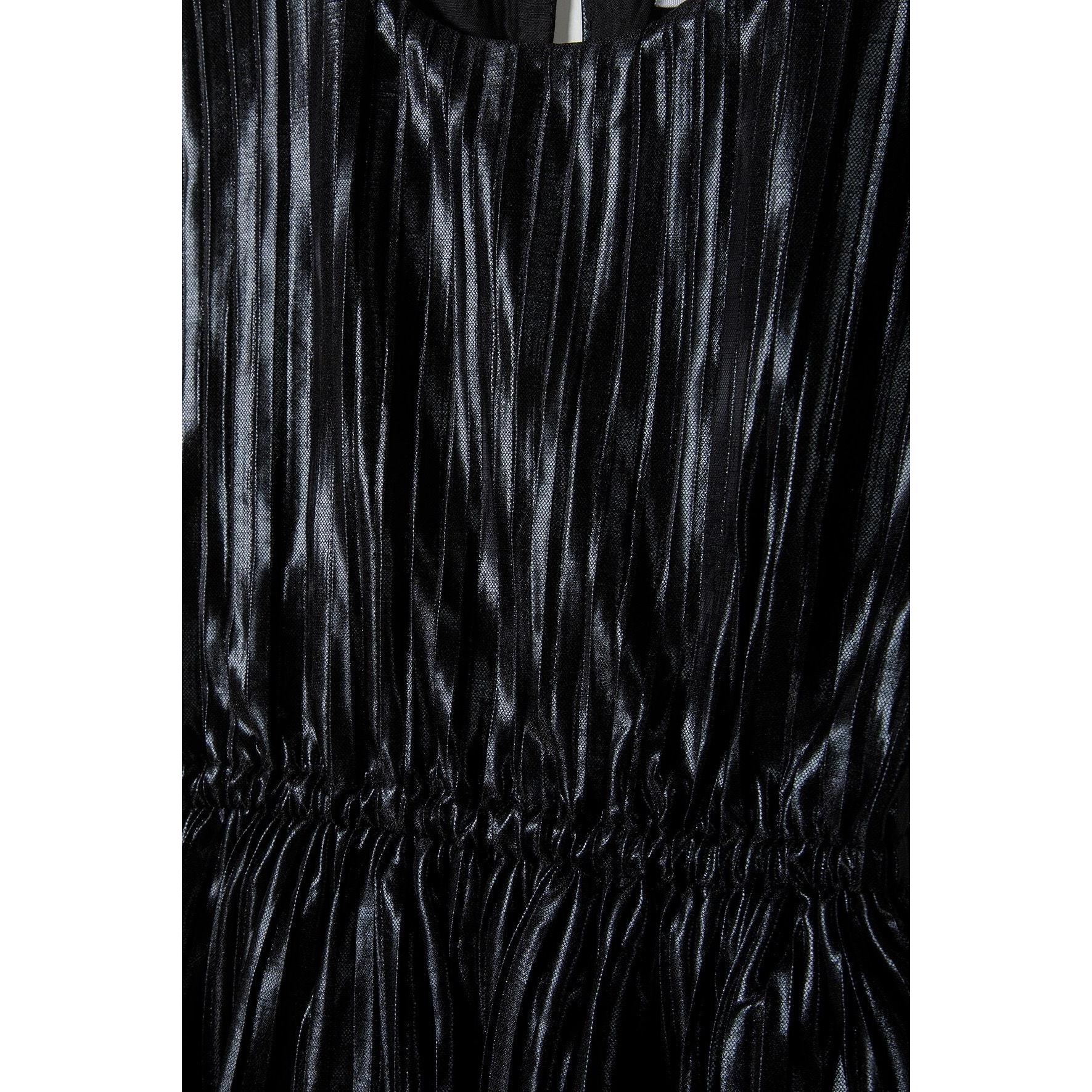 Close-up detail of metallic black pleated fabric texture and elasticated waistband showing fabric quality and construction