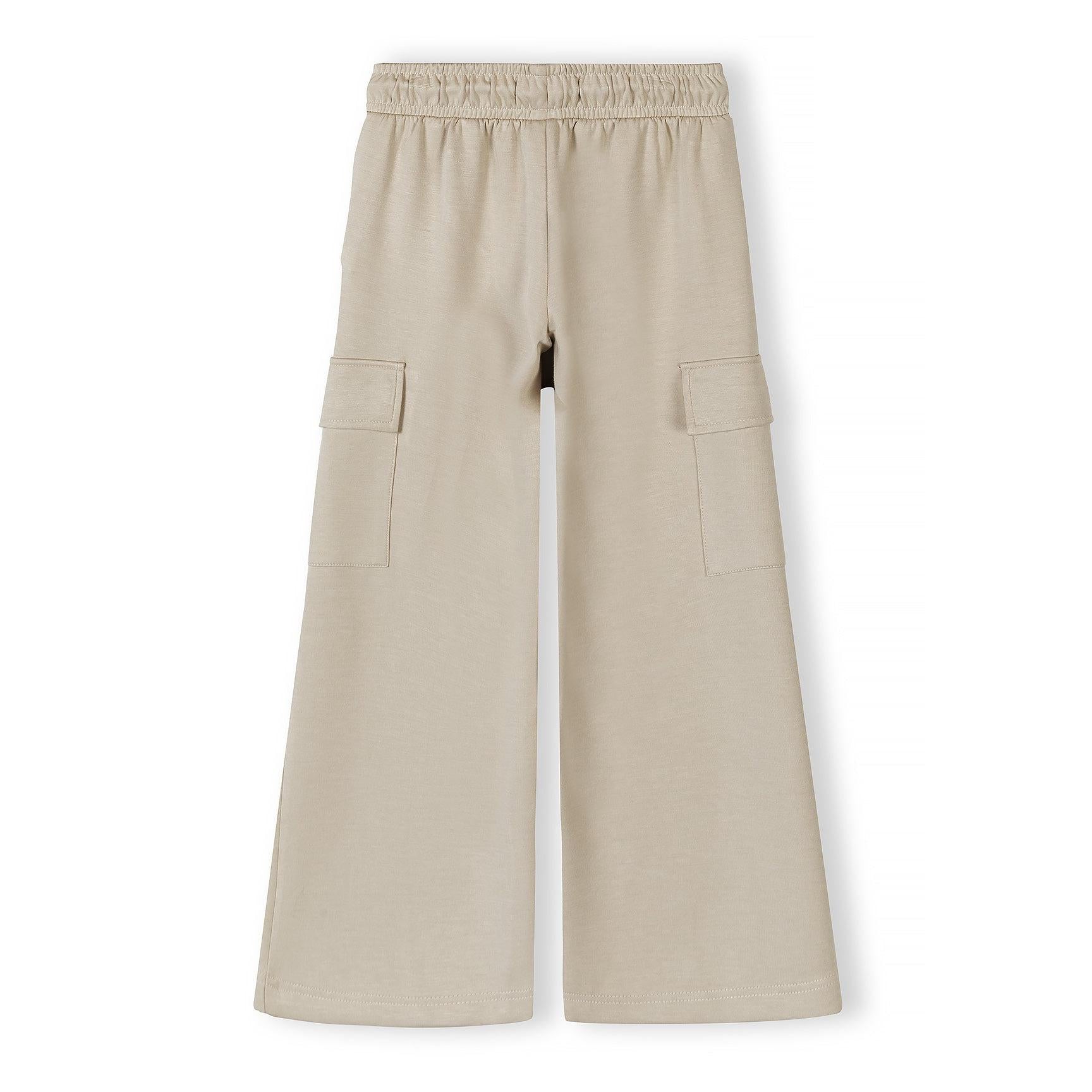 Close-up detail of beige joggers showing elastic waistband with drawstring and front pocket construction