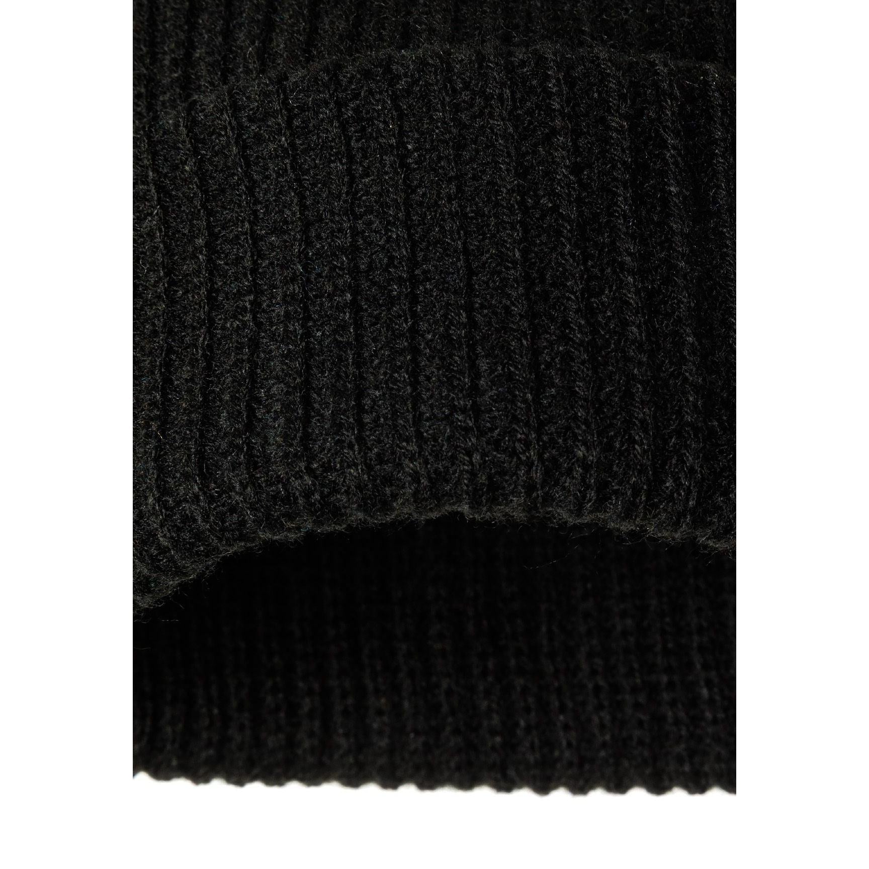 Detail view of black beanie fold-up cuff showing ribbed knit texture and construction quality