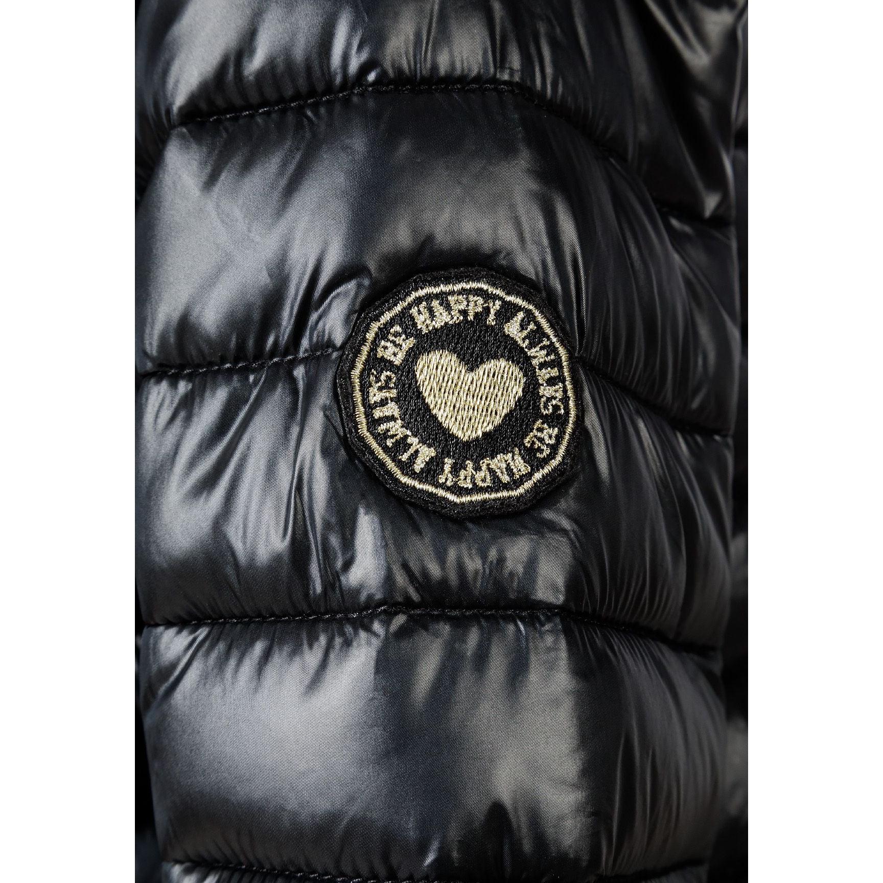 Close-up detail of circular embroidered patch on black quilted jacket sleeve featuring heart design with text around border