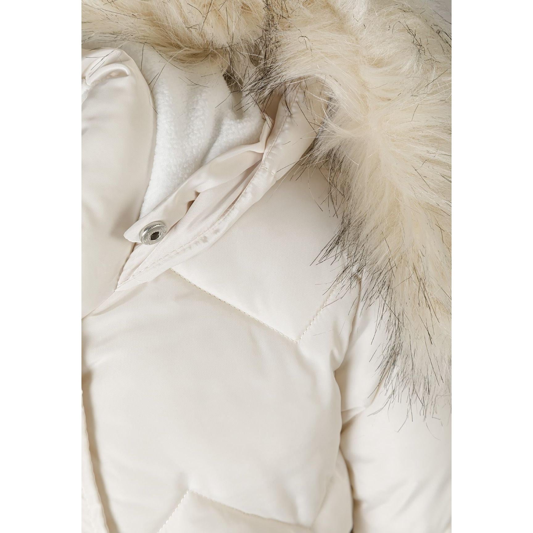 Close-up detail of cream quilted parka jacket showing diamond quilting pattern, faux fur hood trim texture and snap button closure on white background