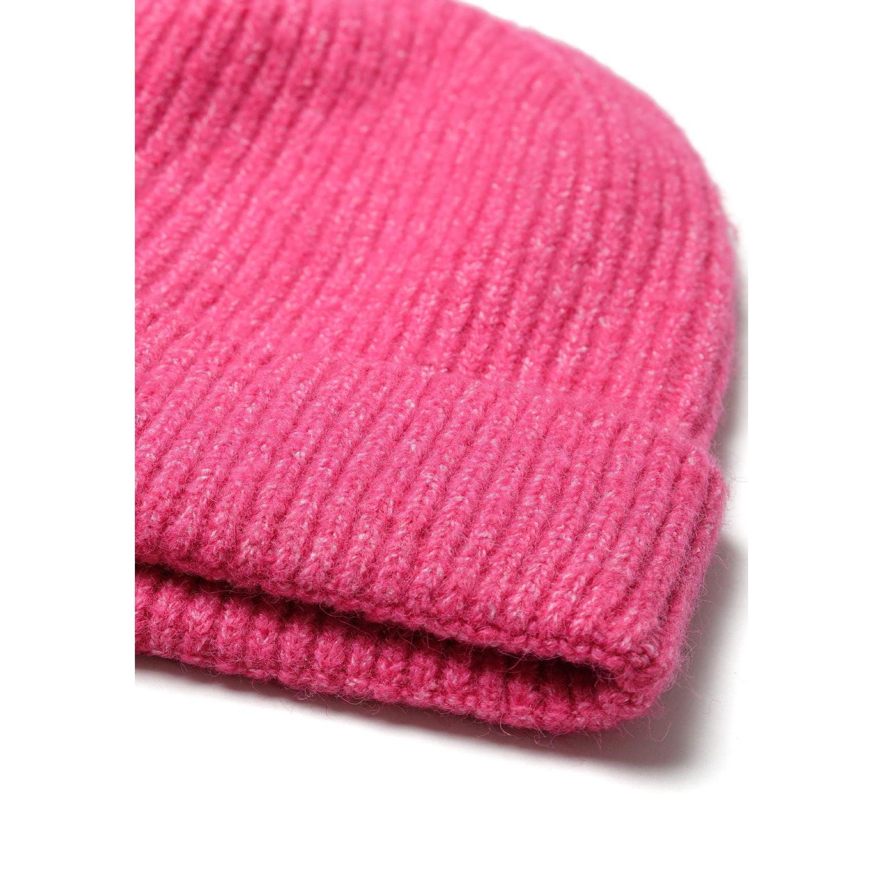 Close-up detail of pink beanie showing ribbed knit texture and folded cuff edge against white background