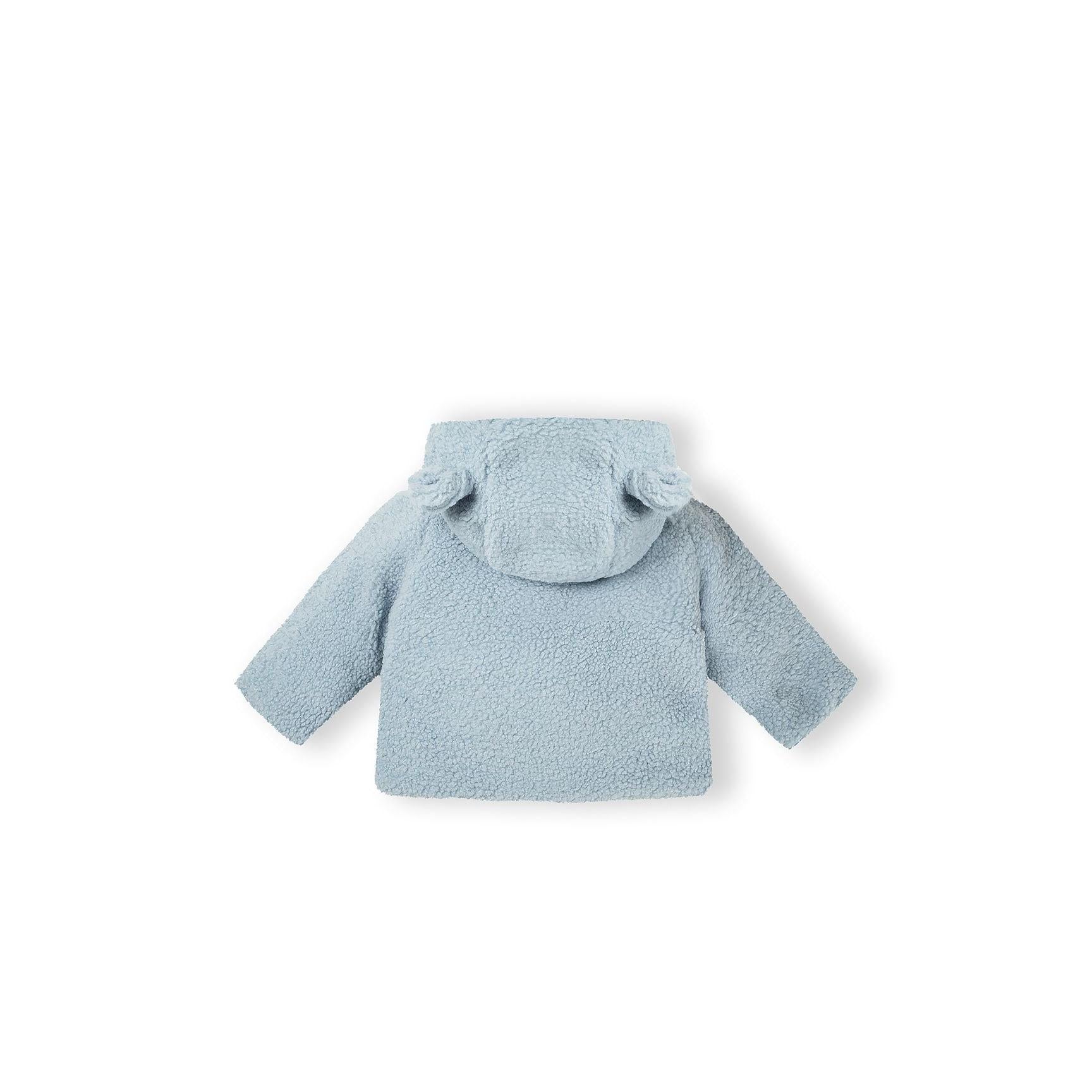 Close-up detail of light blue teddy fleece jacket showing cream jersey lining interior and button fastening mechanism