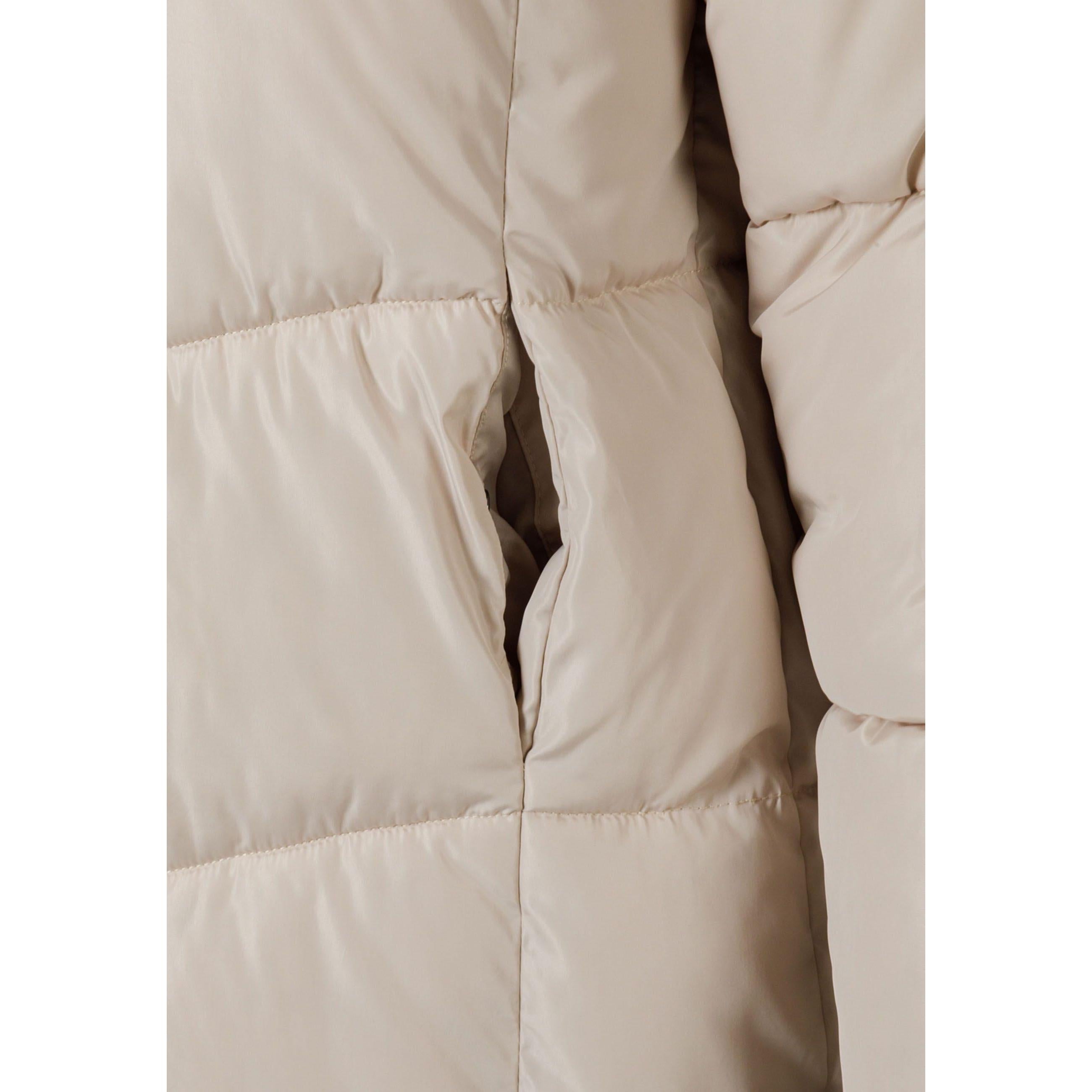 Close-up detail of beige puffer coat quilted fabric texture and stitching construction