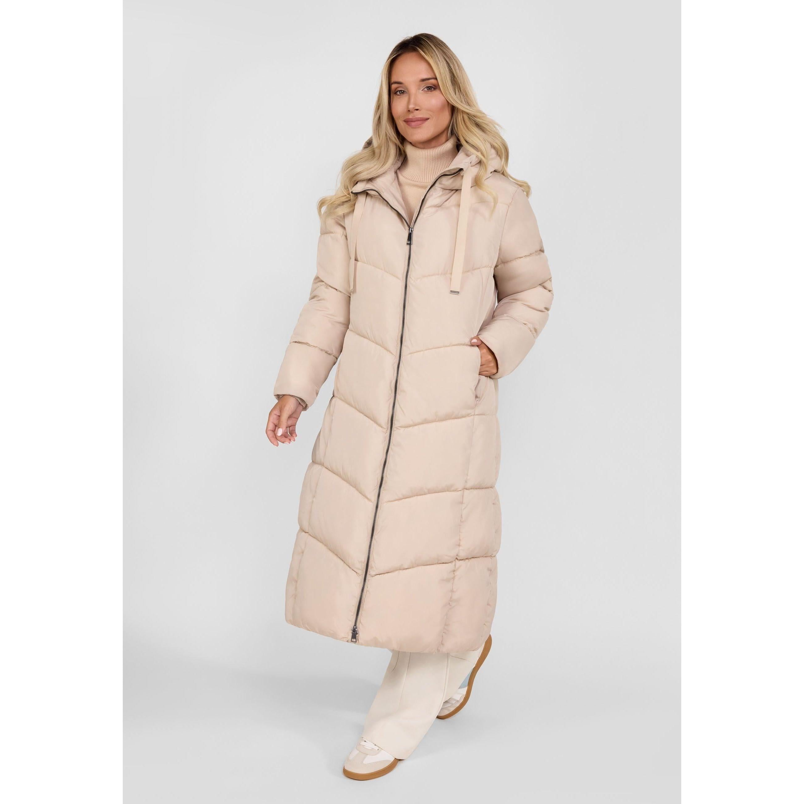 Model wearing beige long puffer coat with hood, front view on light background