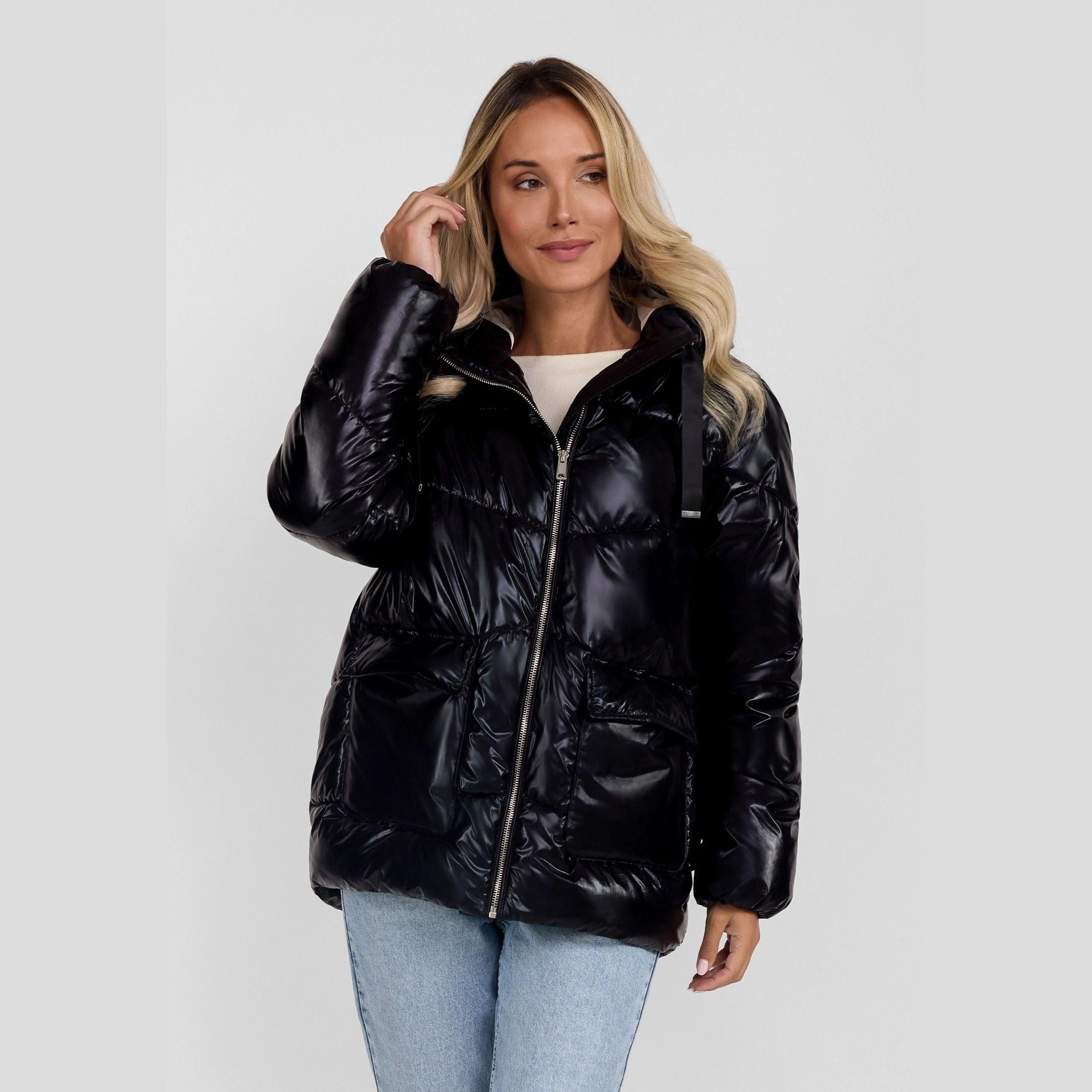 Adult woman wearing black quilted padded jacket with hood, posed against white background