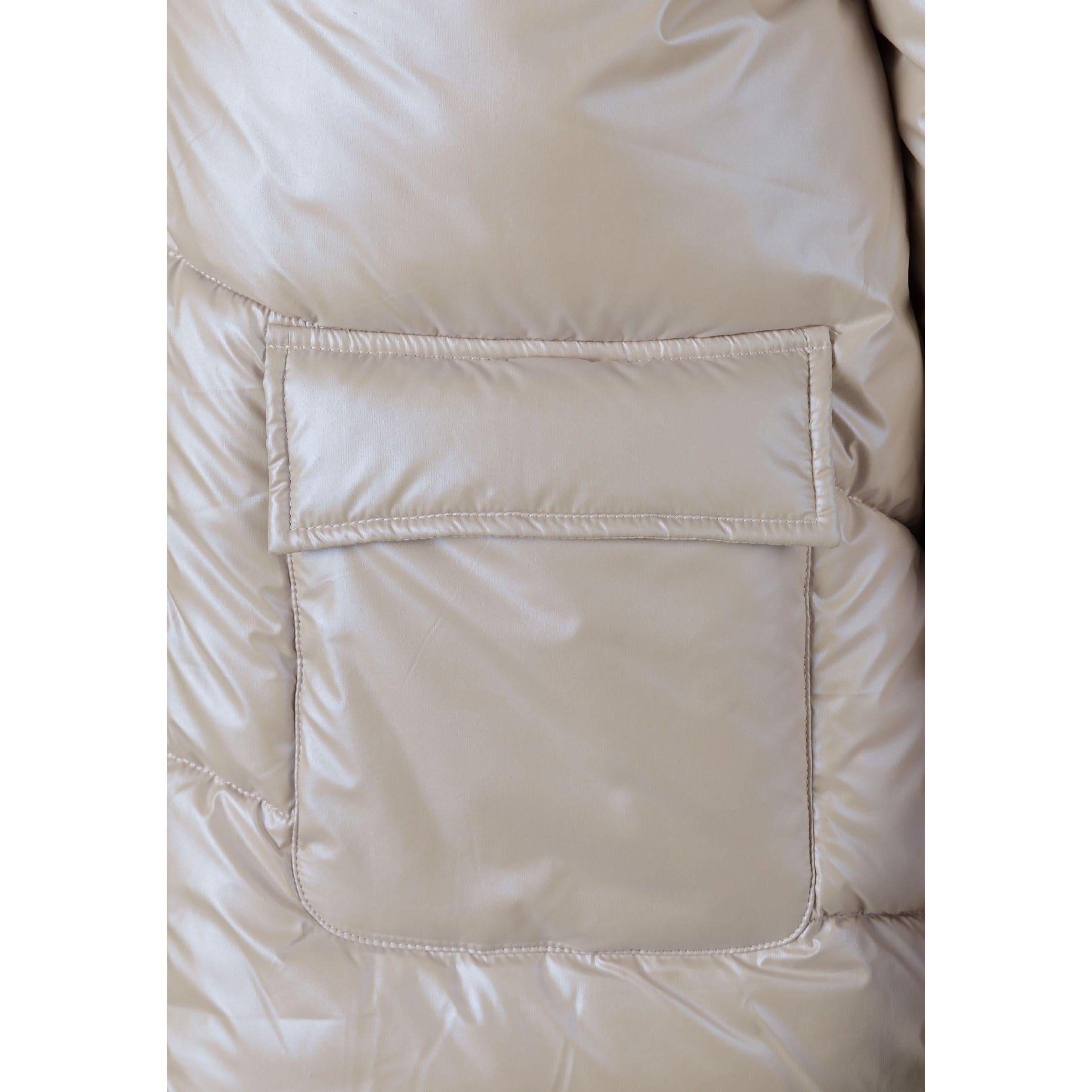 Close-up detail of beige puffer jacket showing front patch pocket with quilted stitching pattern