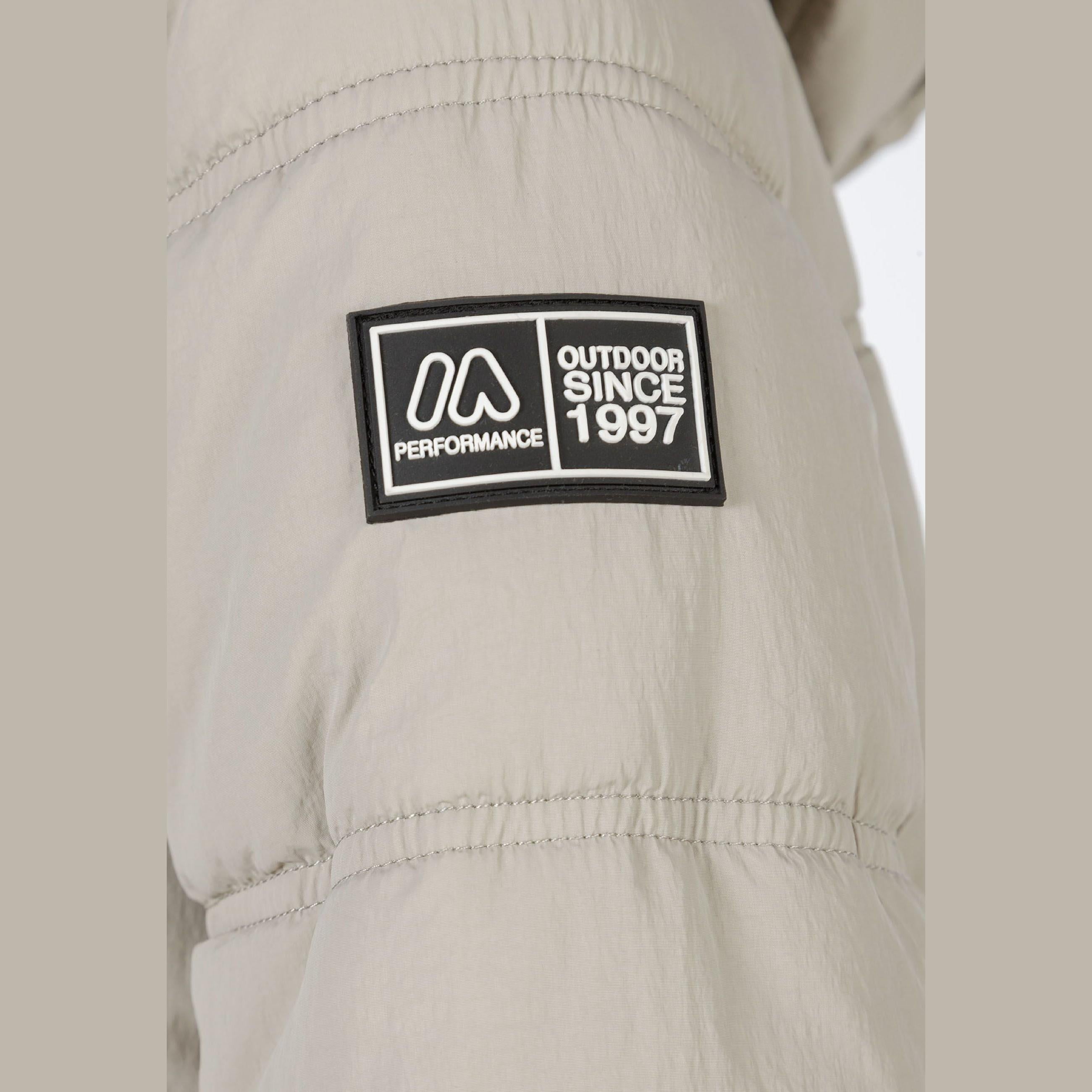 Close-up detail of black rubber performance patch on grey quilted jacket sleeve with outdoor since 1997 text