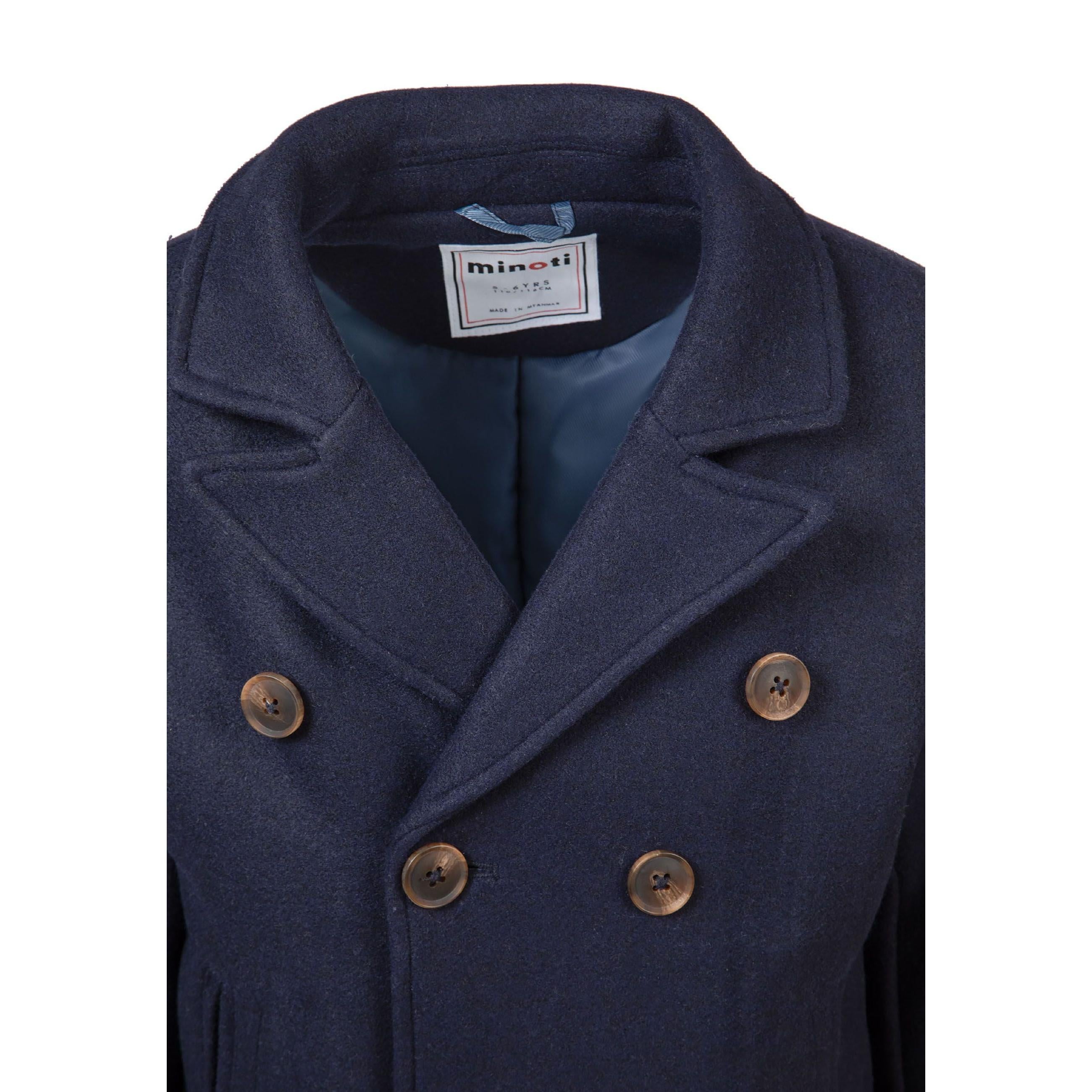 Close-up detail of navy coat pocket showing welt pocket construction and quality fabric texture