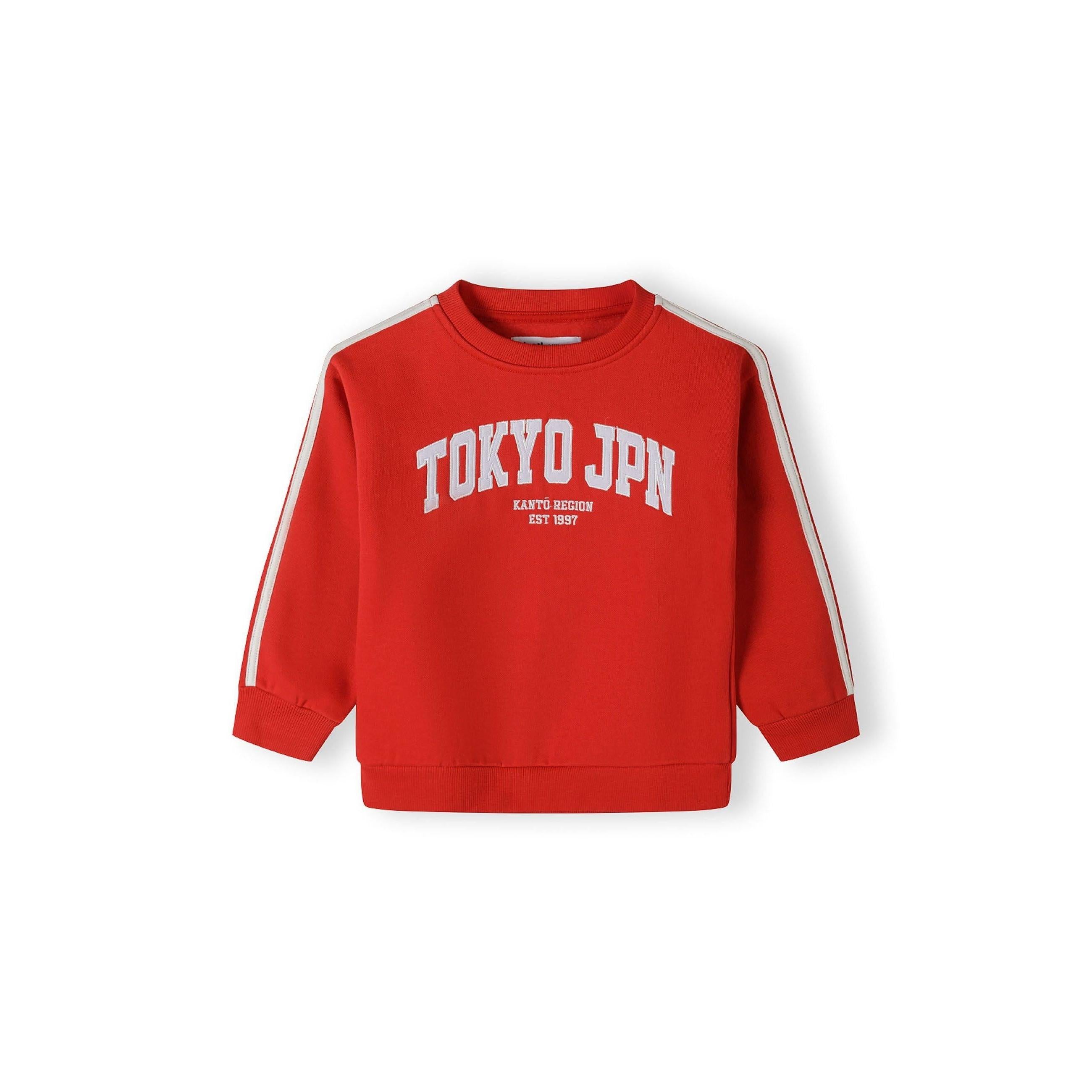 Close-up detail of red joggers showing white drawstring ties and front pocket construction