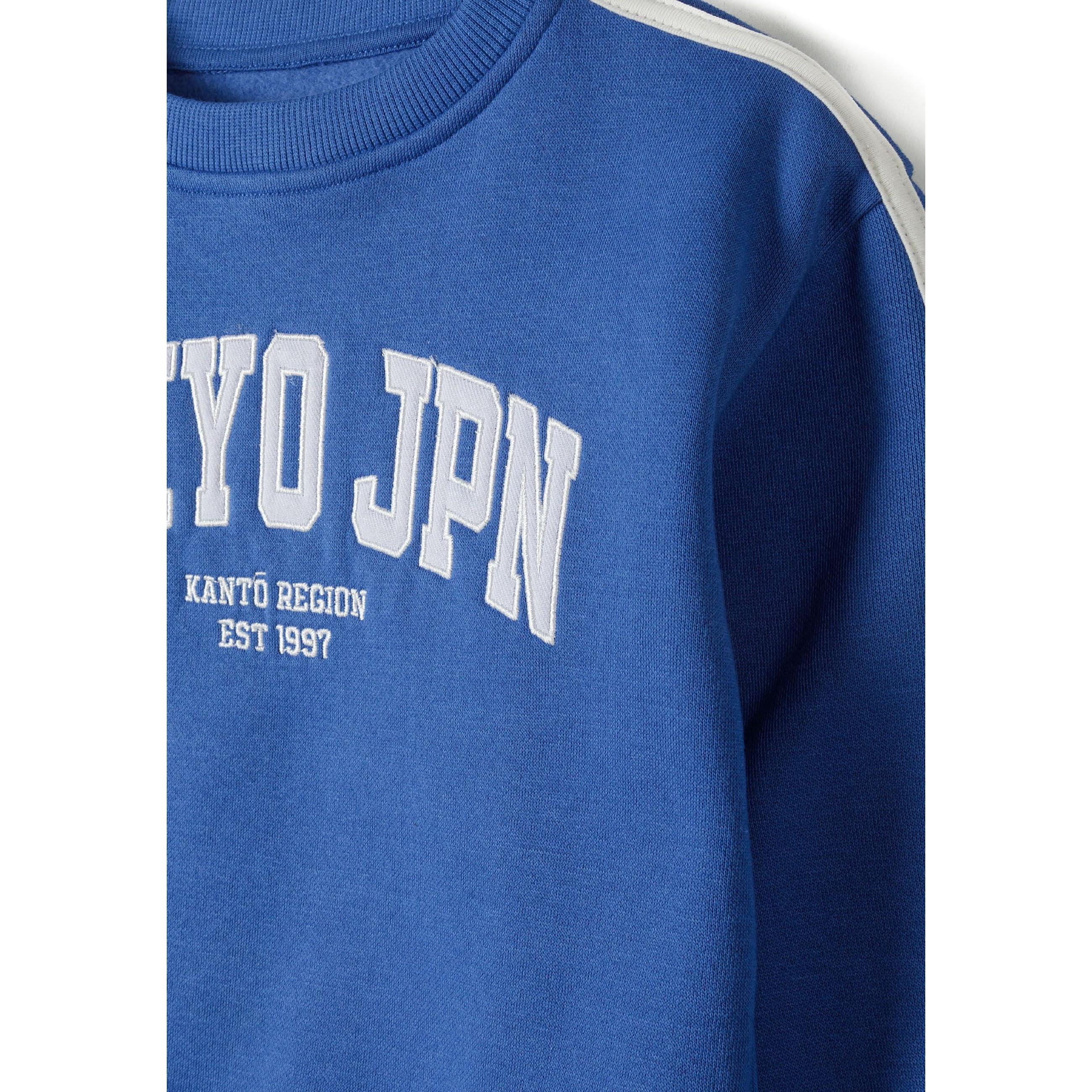 Close-up detail of cobalt blue joggers showing elasticated waistband with white drawstring ties