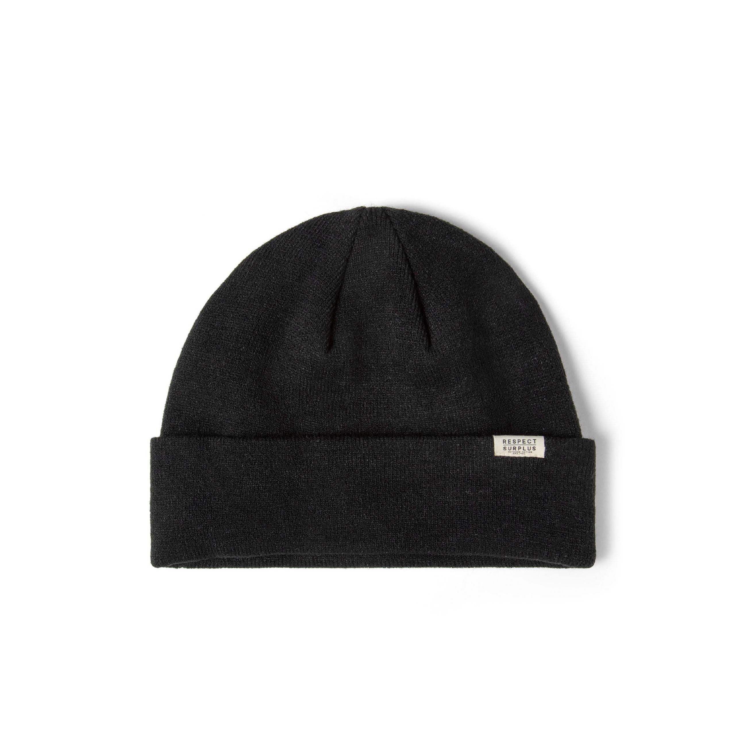 Close-up side view of black ribbed beanie hat showing texture detail and Respect Surplus white label