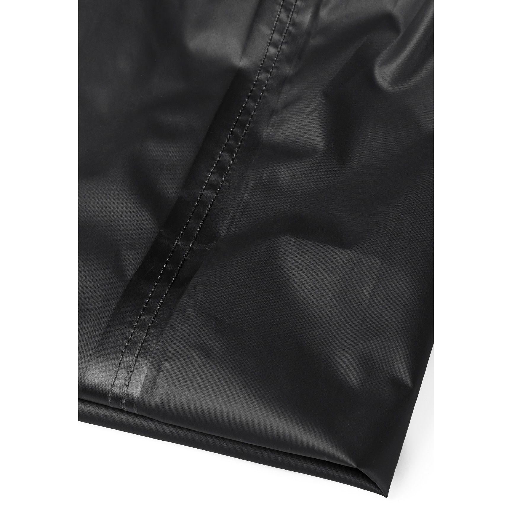 Close-up detail of black waterproof pants showing elastic waistband and taped seams