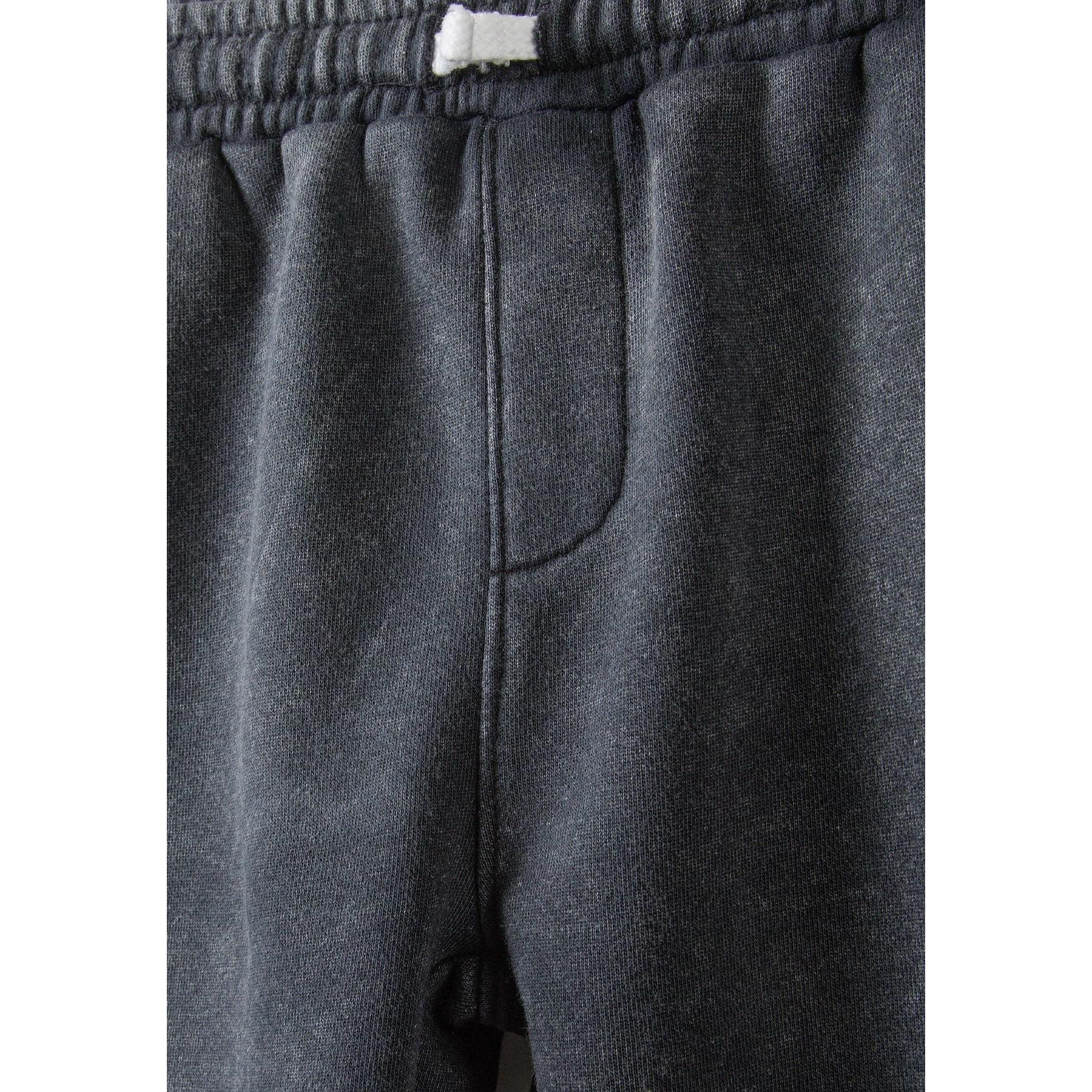 Close-up detail of washed grey fleece shorts showing elasticated waistband with white label and soft fabric texture