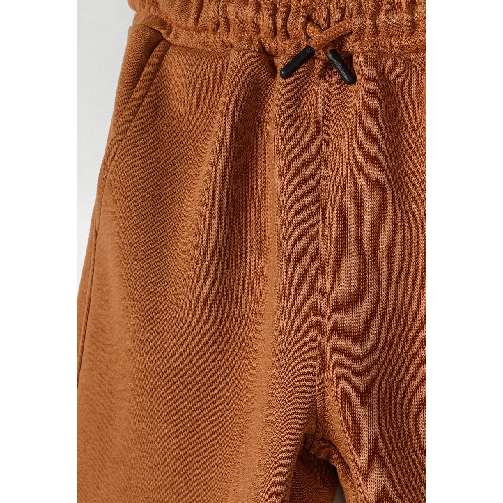 Close-up detail of camel brown shorts showing elasticated waistband with drawstring ties and soft jersey texture