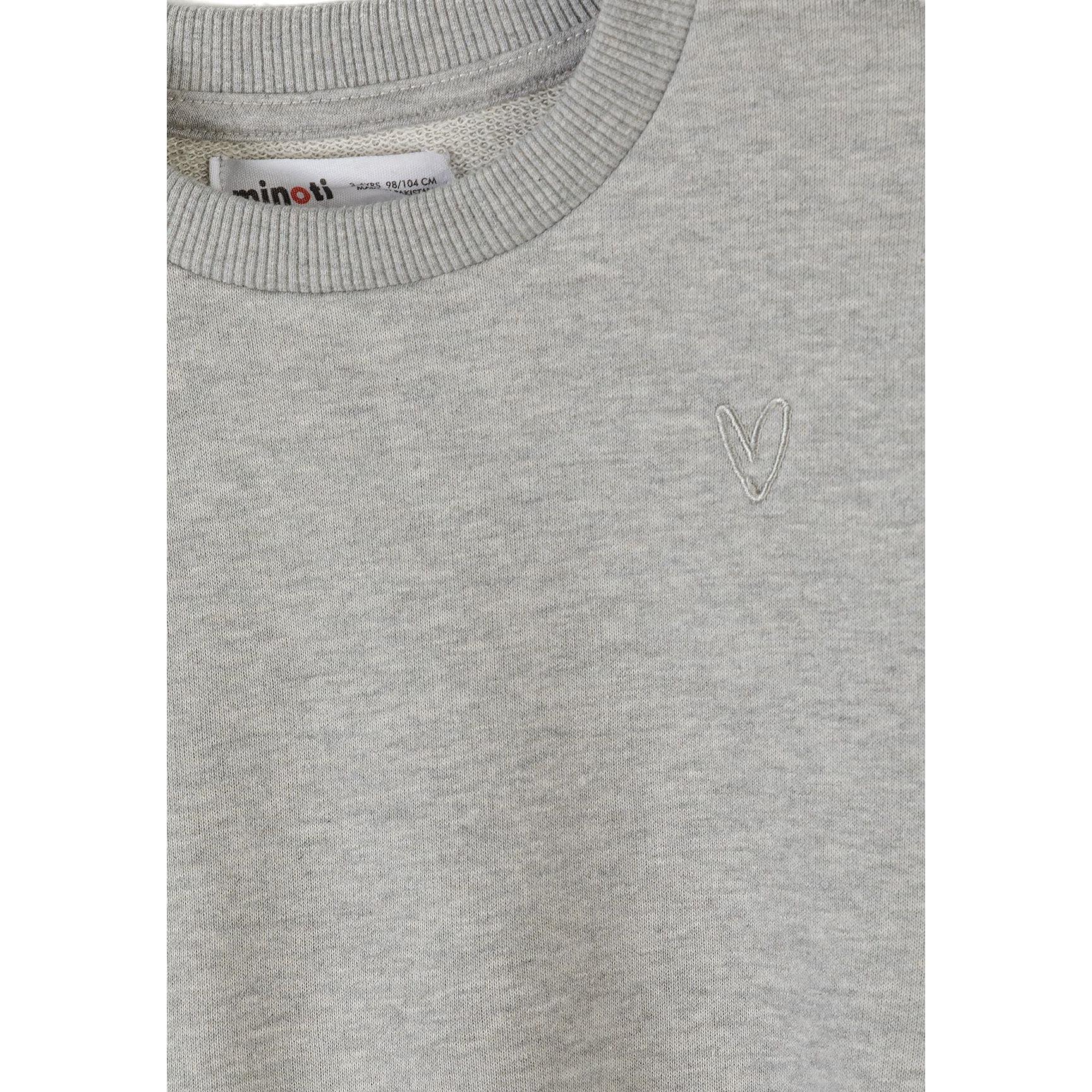 Close-up detail of pink joggers showing Minoti label and drawstring waistband with soft fabric texture