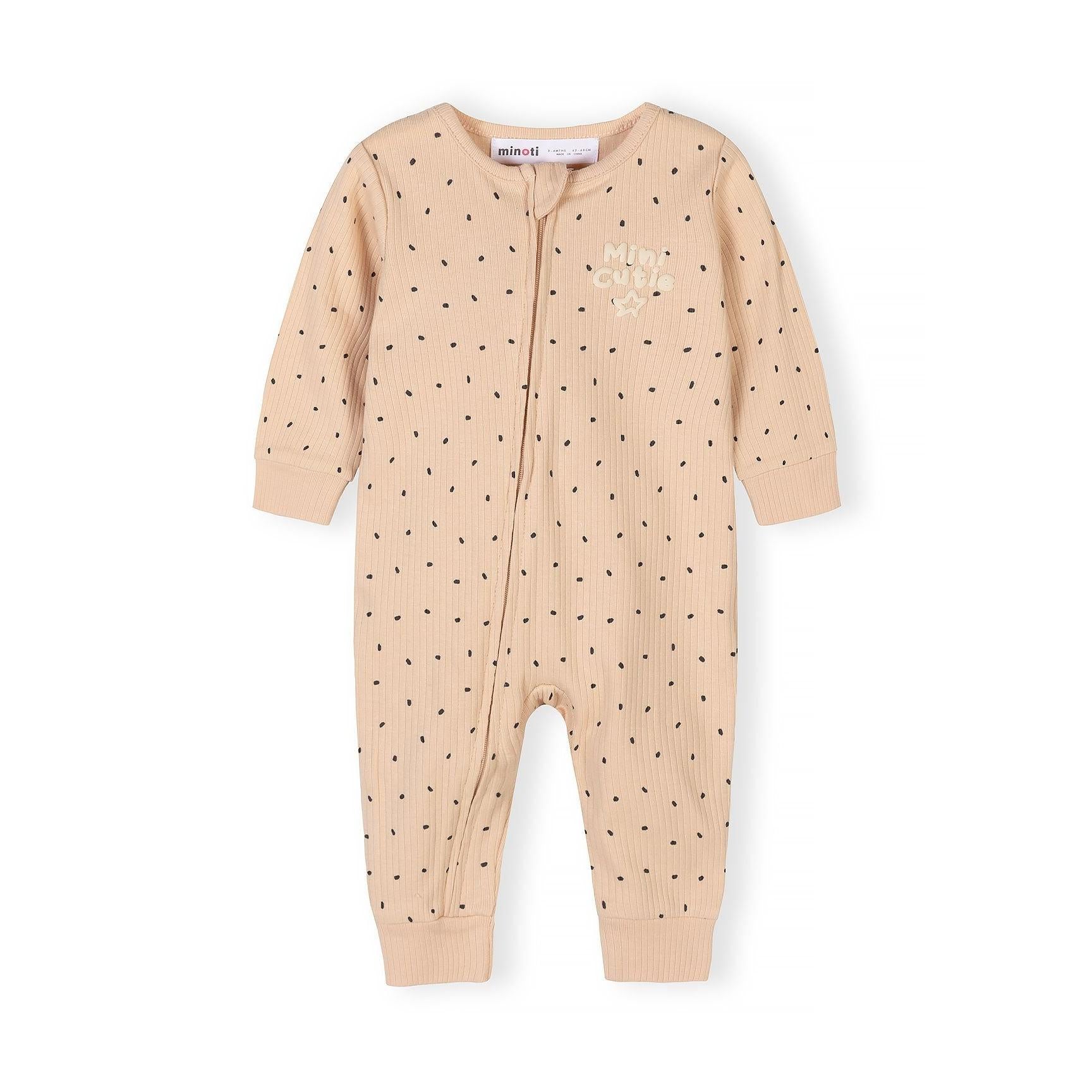 Close-up view of beige polka dot romper with Minoti label showing rib knit texture and front zip detail