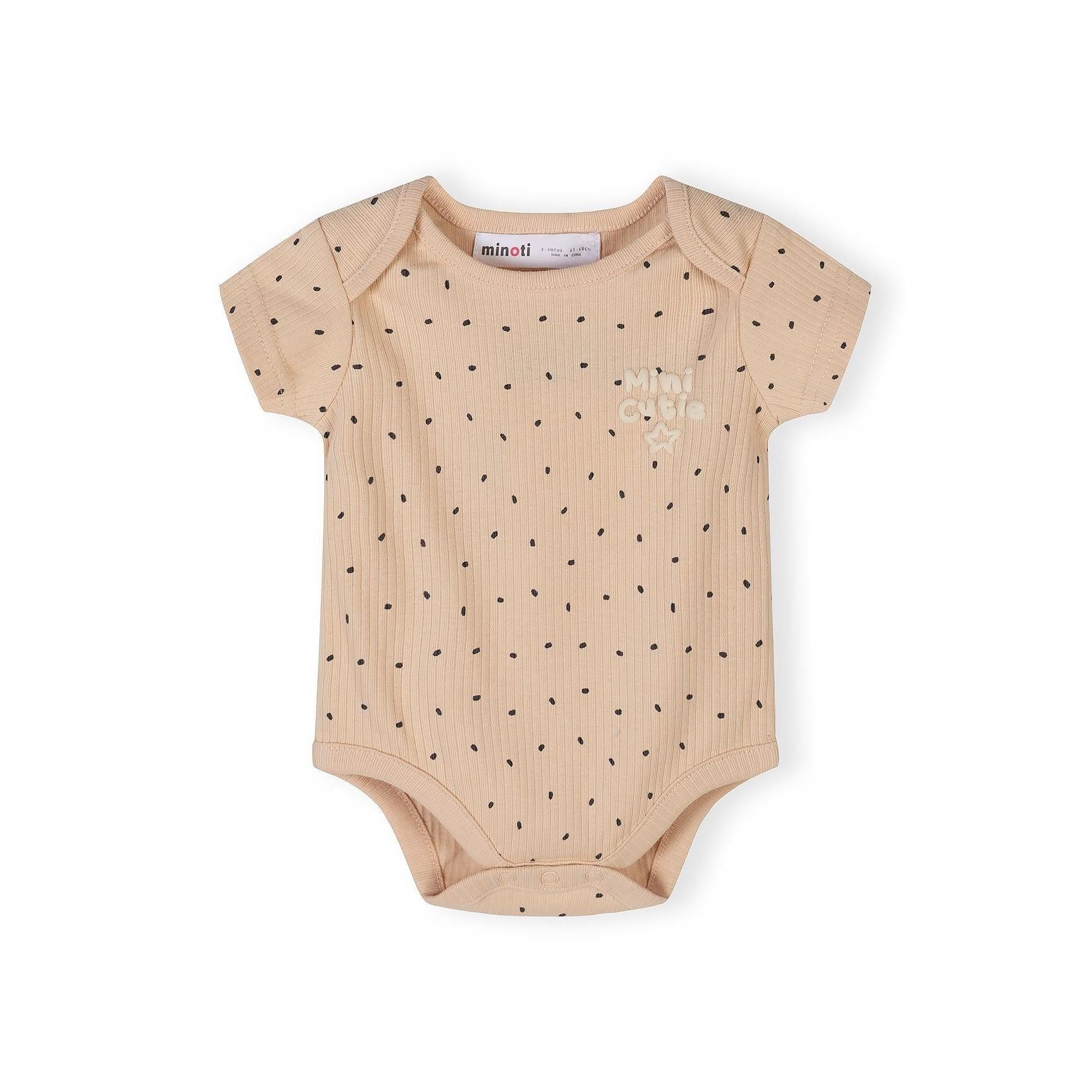 Close-up of beige ribbed bodysuit with black polka dot pattern and Minoti brand label visible at neckline