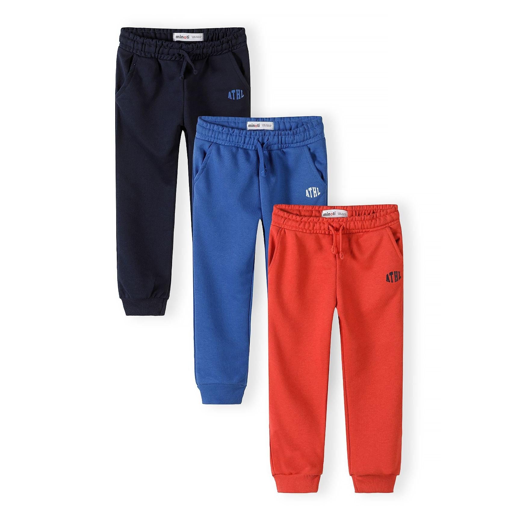 Three athletic joggers displayed flat - navy with blue ATHL logo, royal blue with white ATHL logo, and red with navy ATHL logo, all featuring ribbed cuffs and drawstring waists