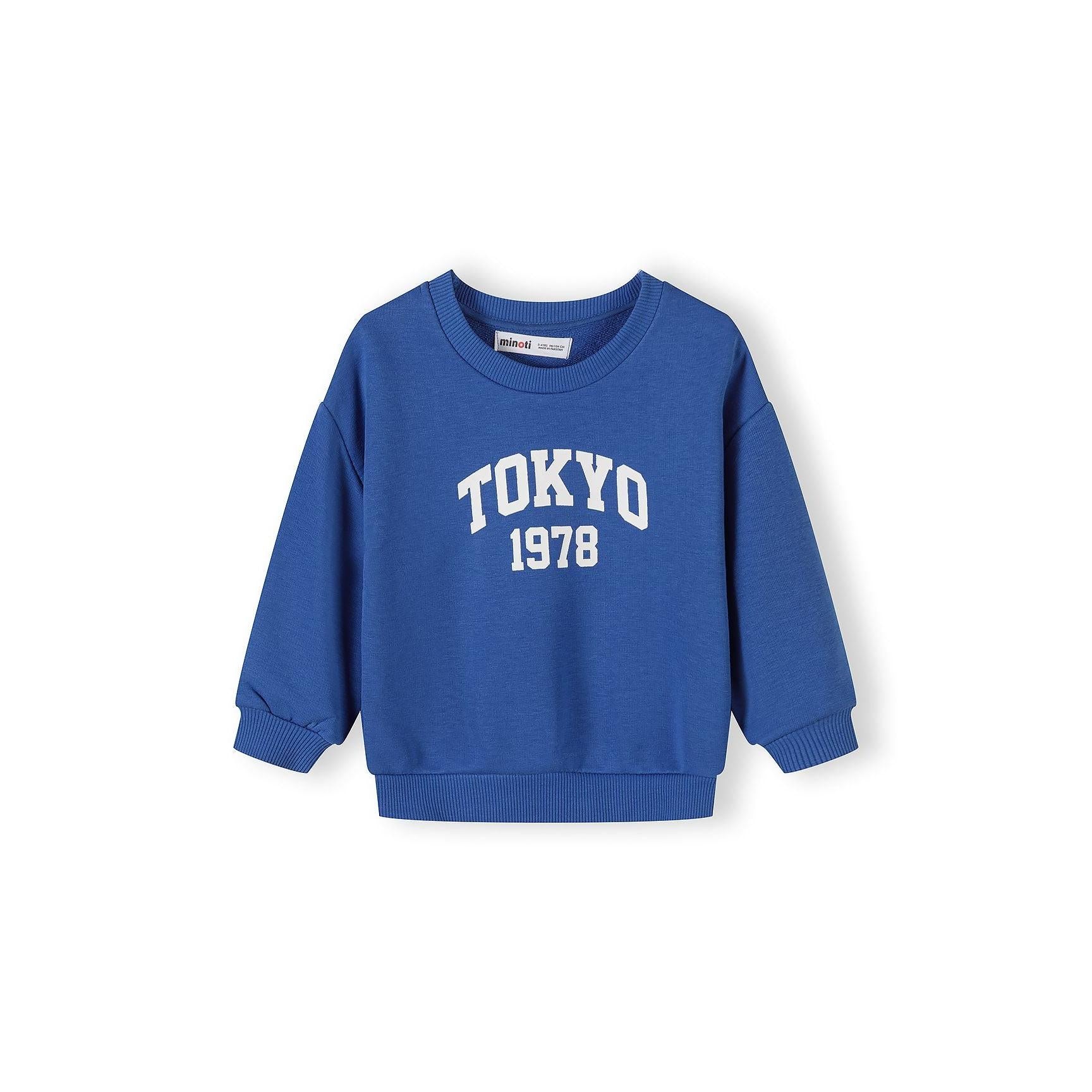 Close-up of red sweatshirt with unlimited power graphic featuring blue text and small design elements on chest area, showing ribbed crew neckline and cuffs