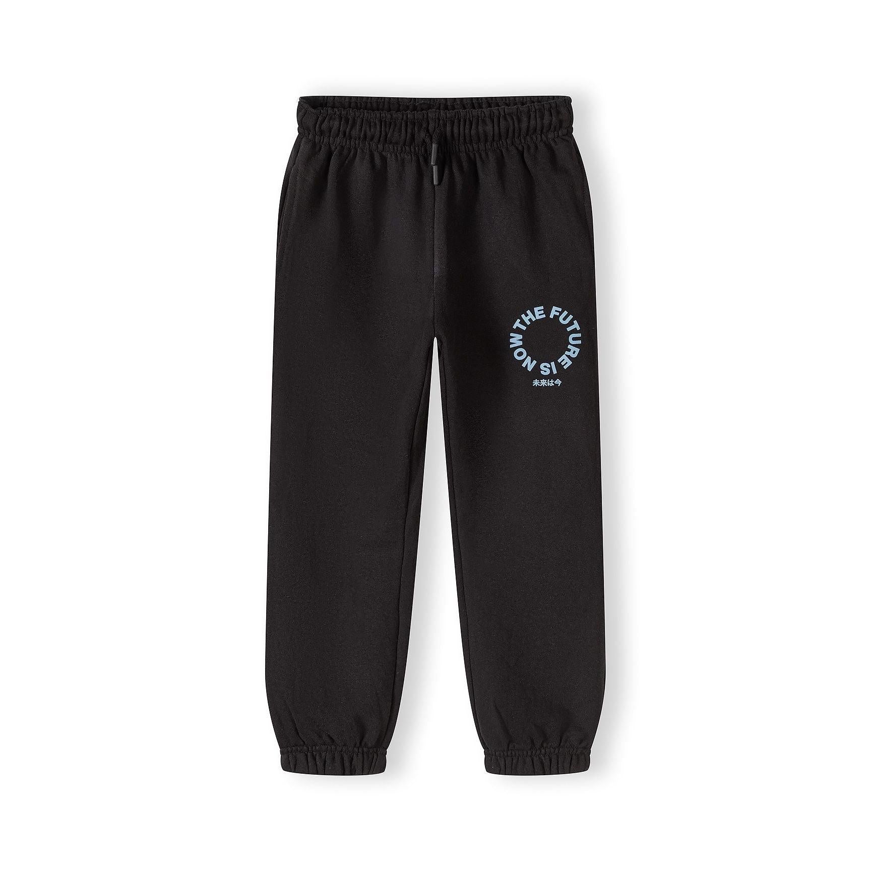 Black joggers with elastic waistband and drawstring, featuring circular printed text design on leg, displayed flat on white background