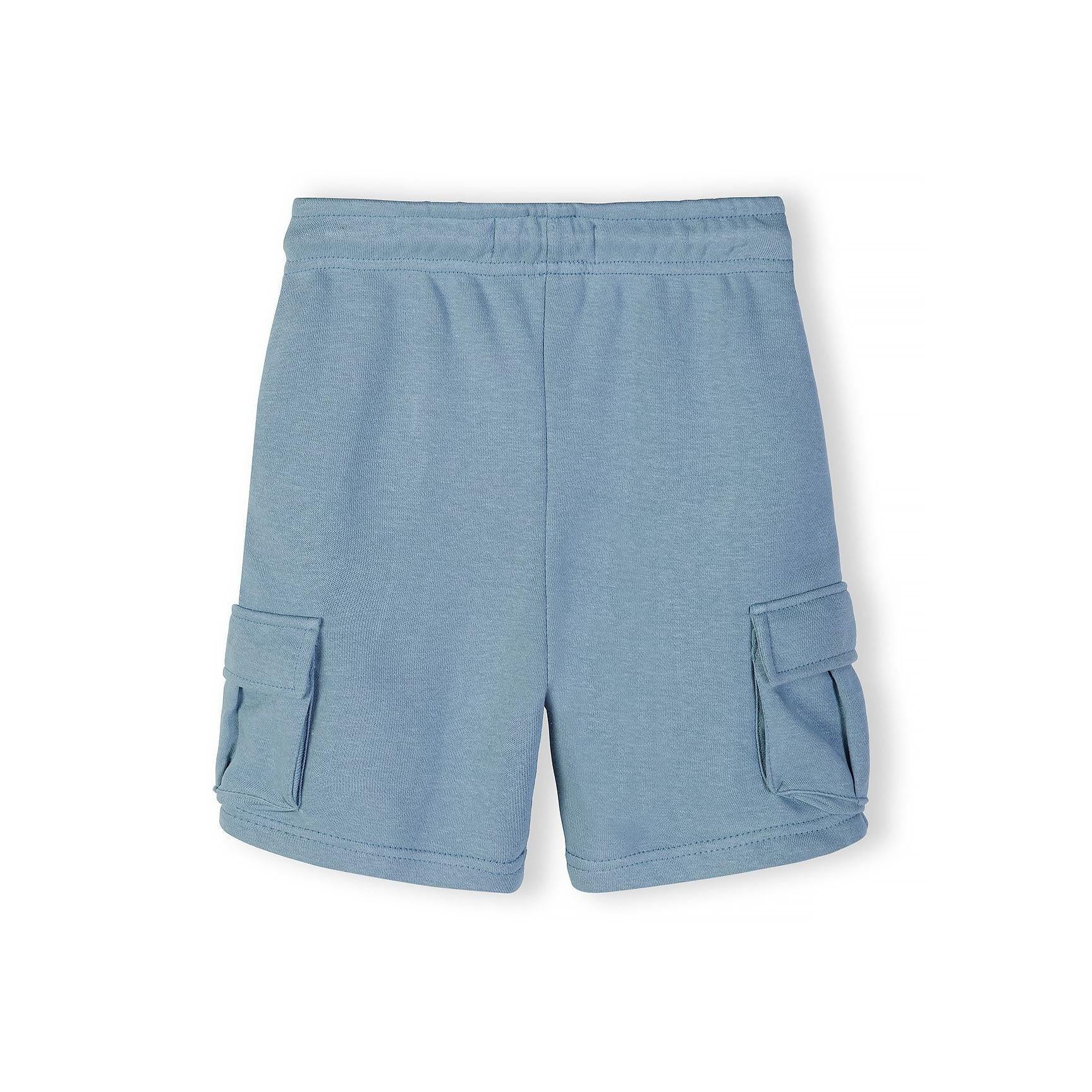 Close-up detail of front chest area showing circular 'The Future is Now' text print with Japanese characters on blue grey fabric