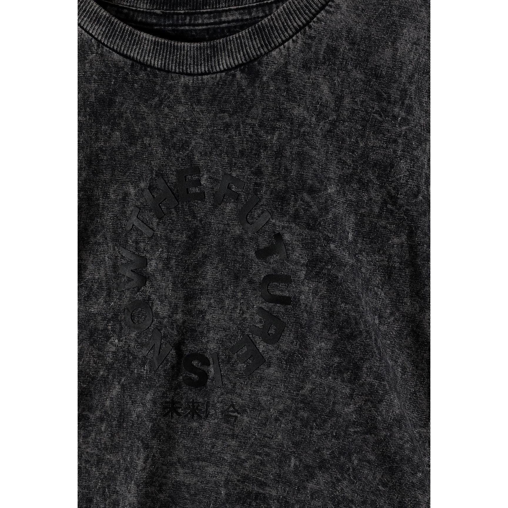Close-up detail of grey acid wash fabric texture showing circular logo print and neckline construction
